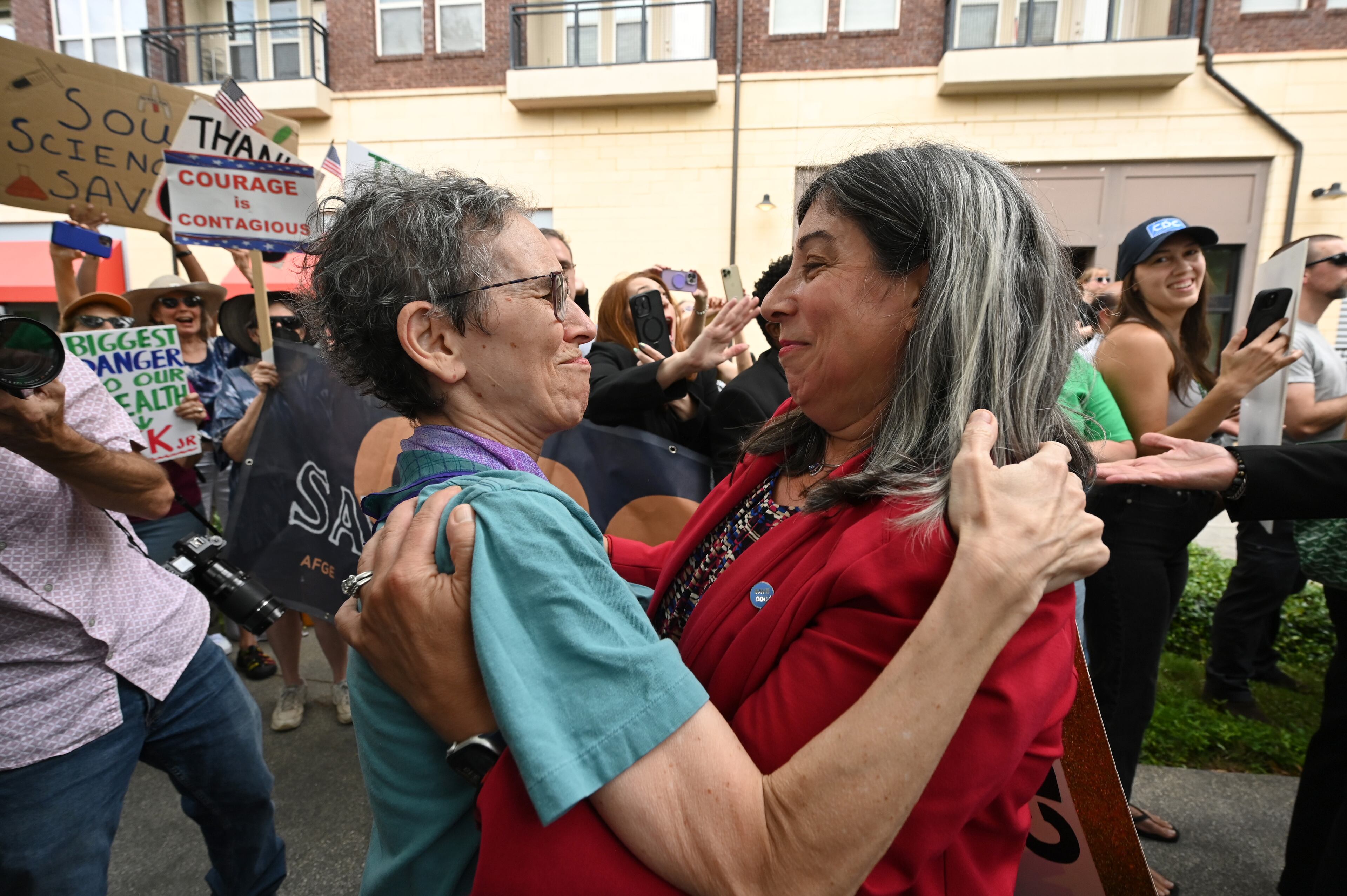 Dr. Debra Houry (right), the agency's deputy director, gets a hug as CDC staff and supporters gather to rally for departing leaders outside the CDC headquarters, Thursday, August 28, 2025, in Atlanta. Top leaders who resigned their positions at the US Centers for Disease Control and Prevention after the ouster of the agency’s director were escorted out of the building Thursday morning. (Hyosub Shin / AJC)