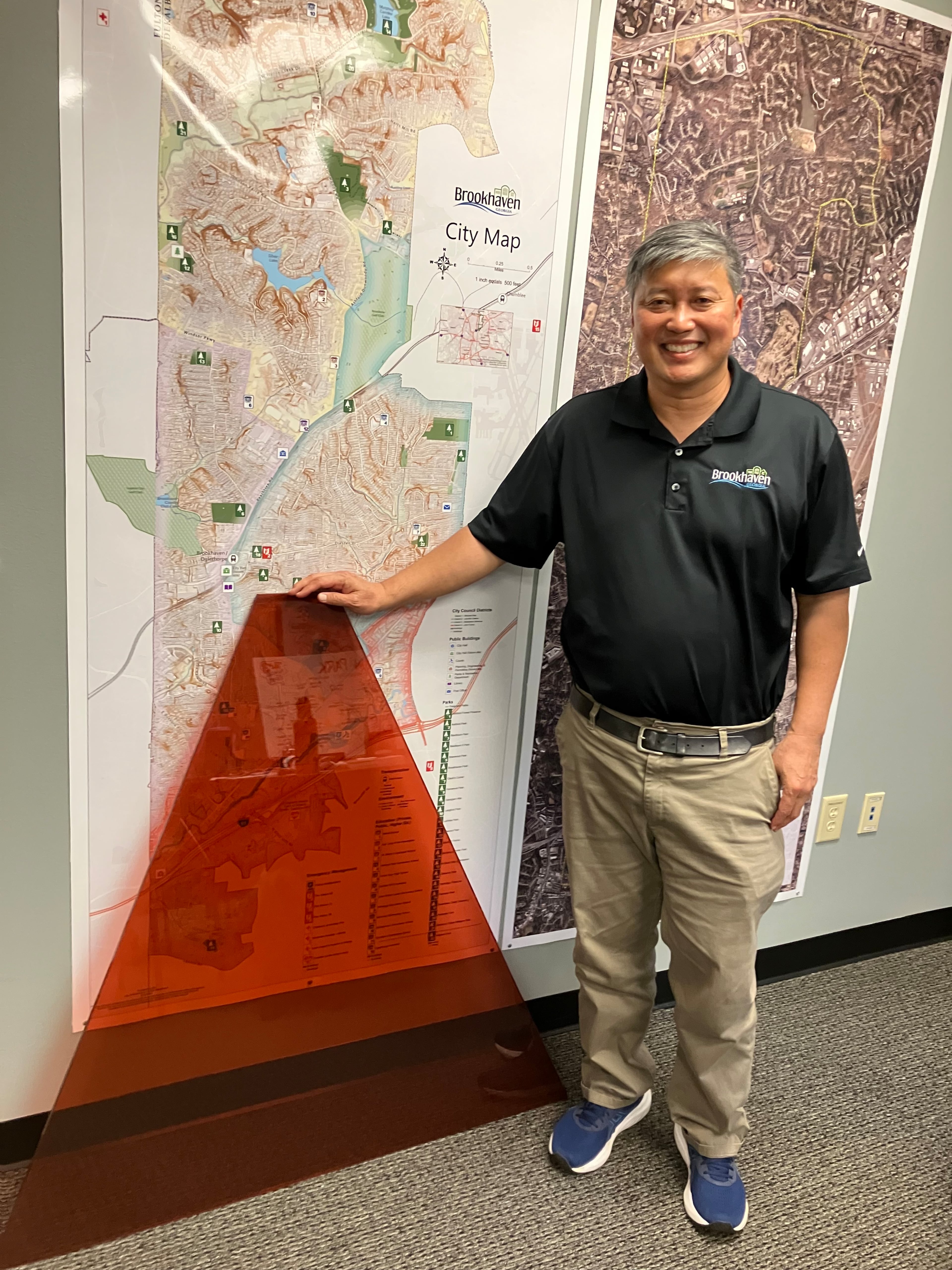 Brookhaven Mayor John Park, here showing off one of the glass panes to be installed in the City Centre's dome, said “The primary colors didn’t mesh with the rest of the design of the building. It distracted from that kind of muted design principle we put forth." (Reed Williams/AJC)