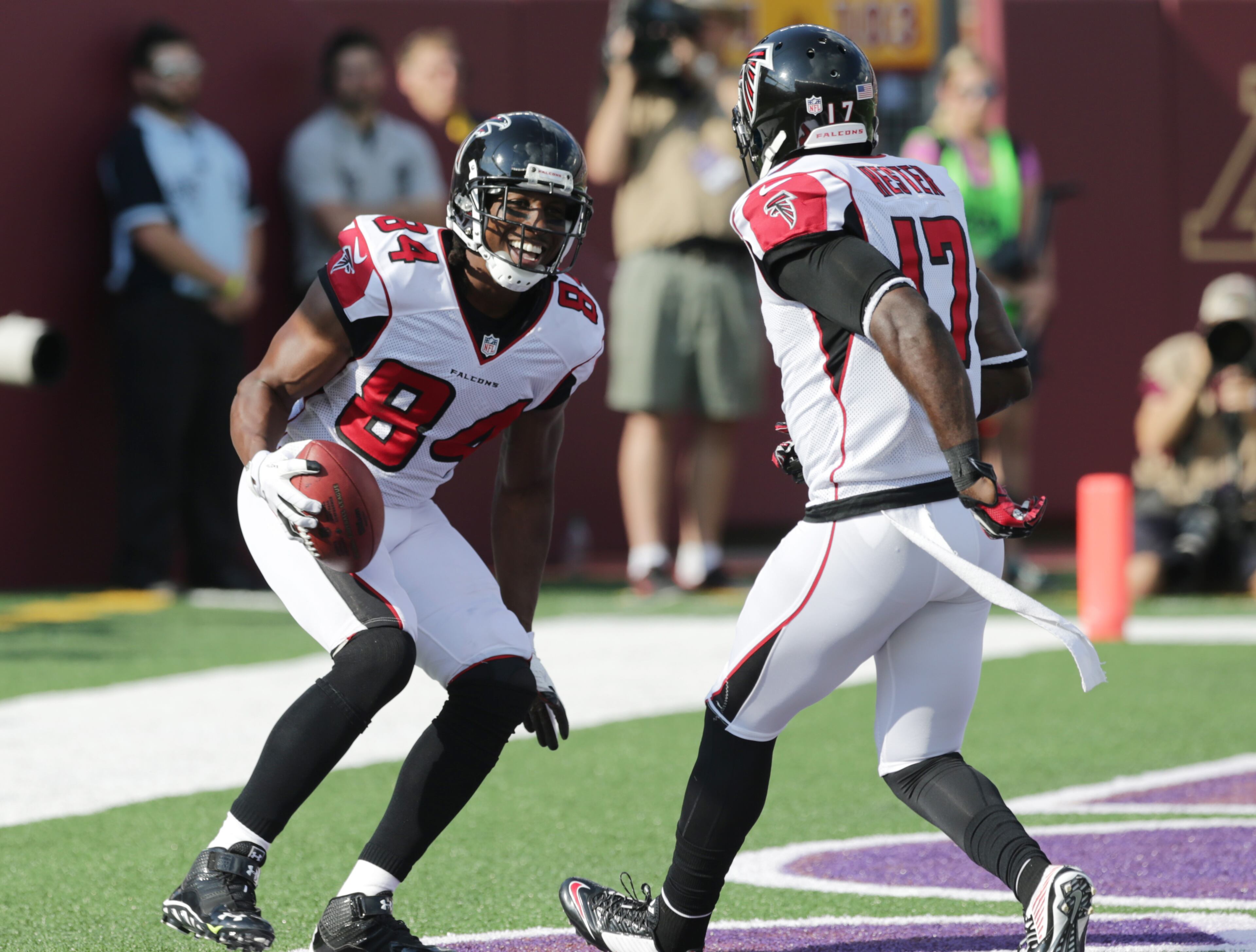 Atlanta Falcons wide receiver Roddy White (84) reacts with teammate Devin Hester (17) after catching a 24-yard touchdown pass during the first half of an NFL football game against the Minnesota Vikings, Sunday, Sept. 28, 2014, in Minneapolis. (AP Photo/Jim Mone)