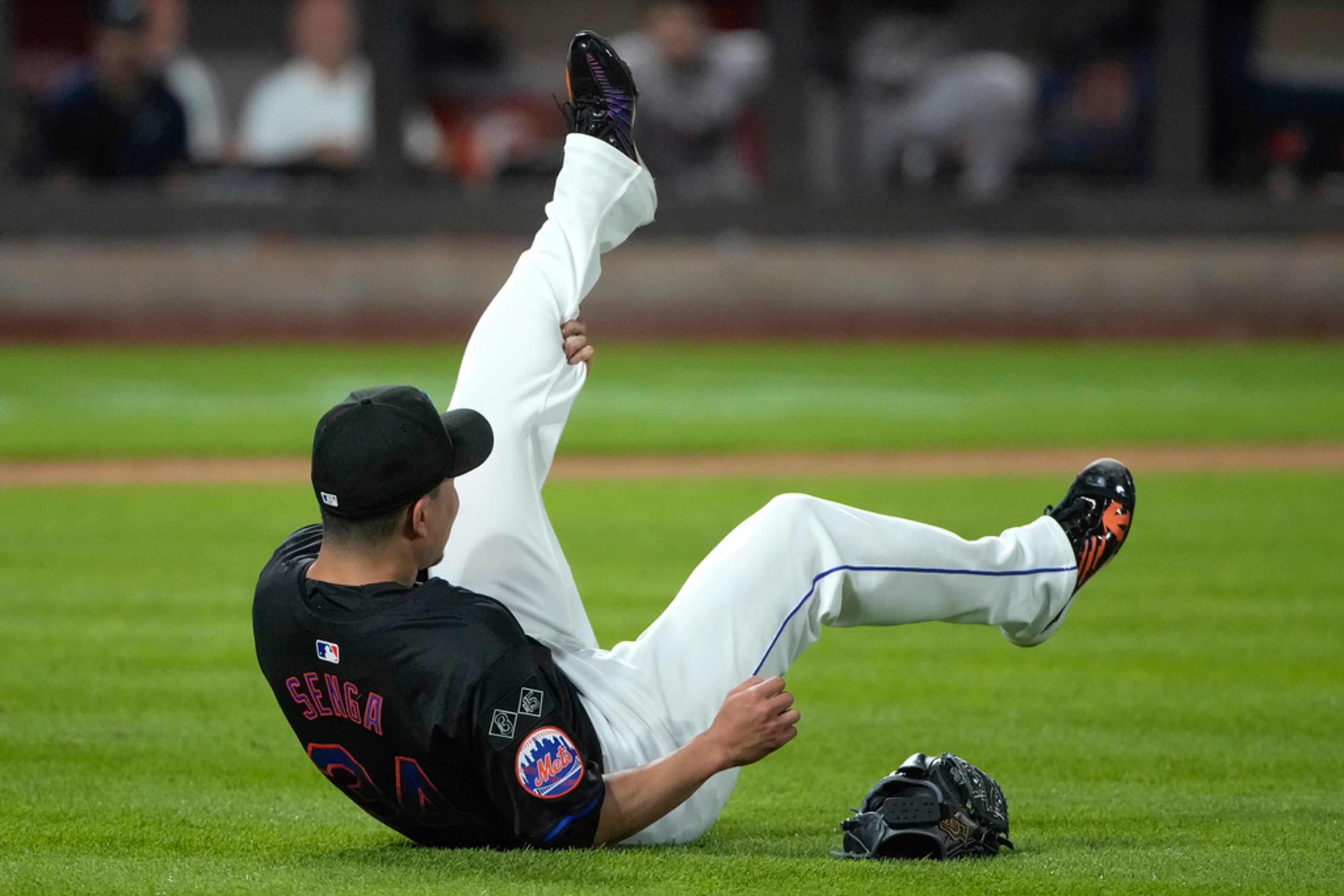 New York Mets' Kodai Senga grabs his leg as he reacts to an injury during the sixth inning of a baseball game against the Atlanta Braves, Friday, July 26, 2024, in New York. (AP Photo/Pamela Smith)