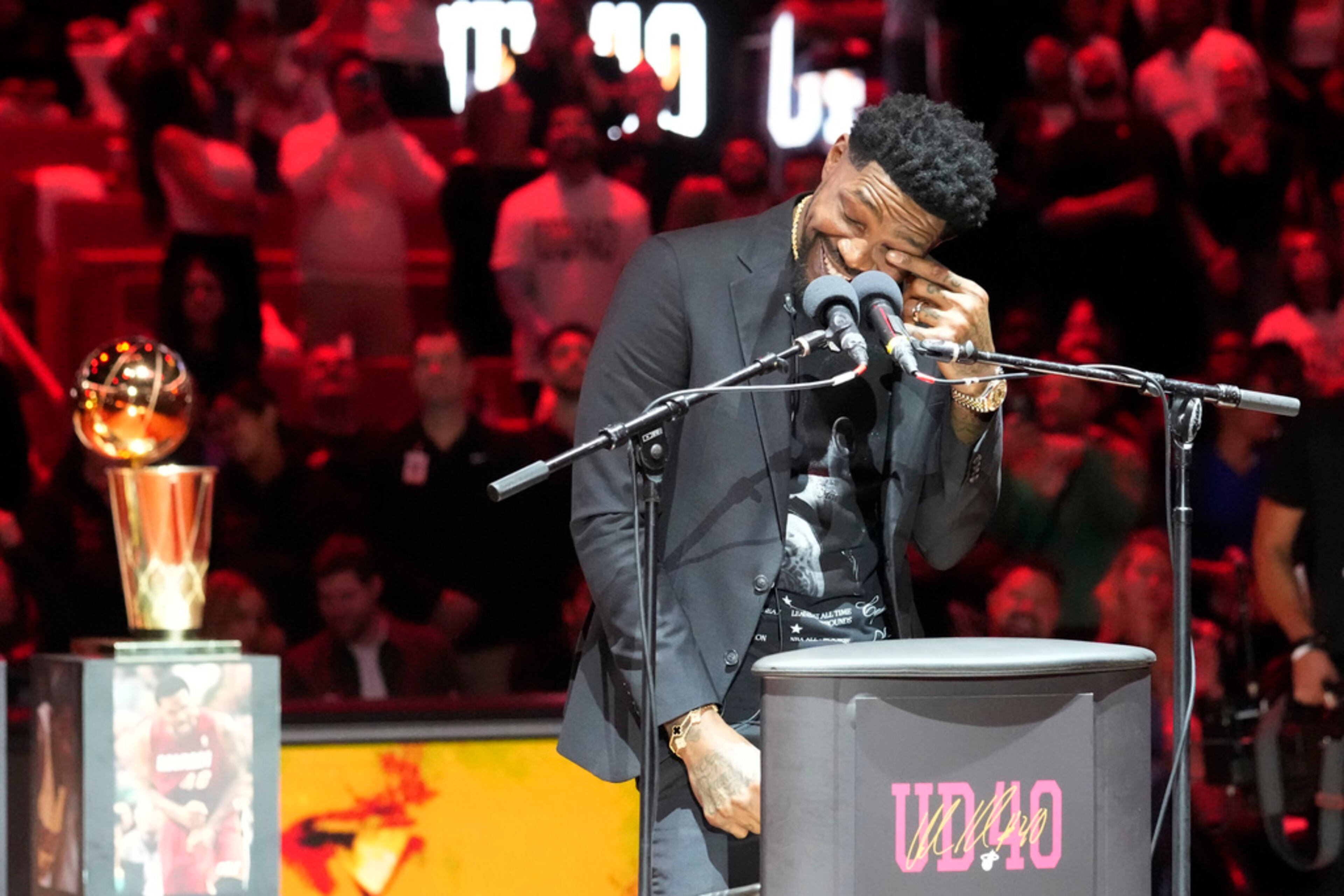 Former Miami Heat player Udonis Haslem wipes a tear during a half time ceremony where his jersey was retired at an NBA basketball game against the Atlanta Hawks, Friday, Jan. 19, 2024, in Miami. (AP Photo/Marta Lavandier)