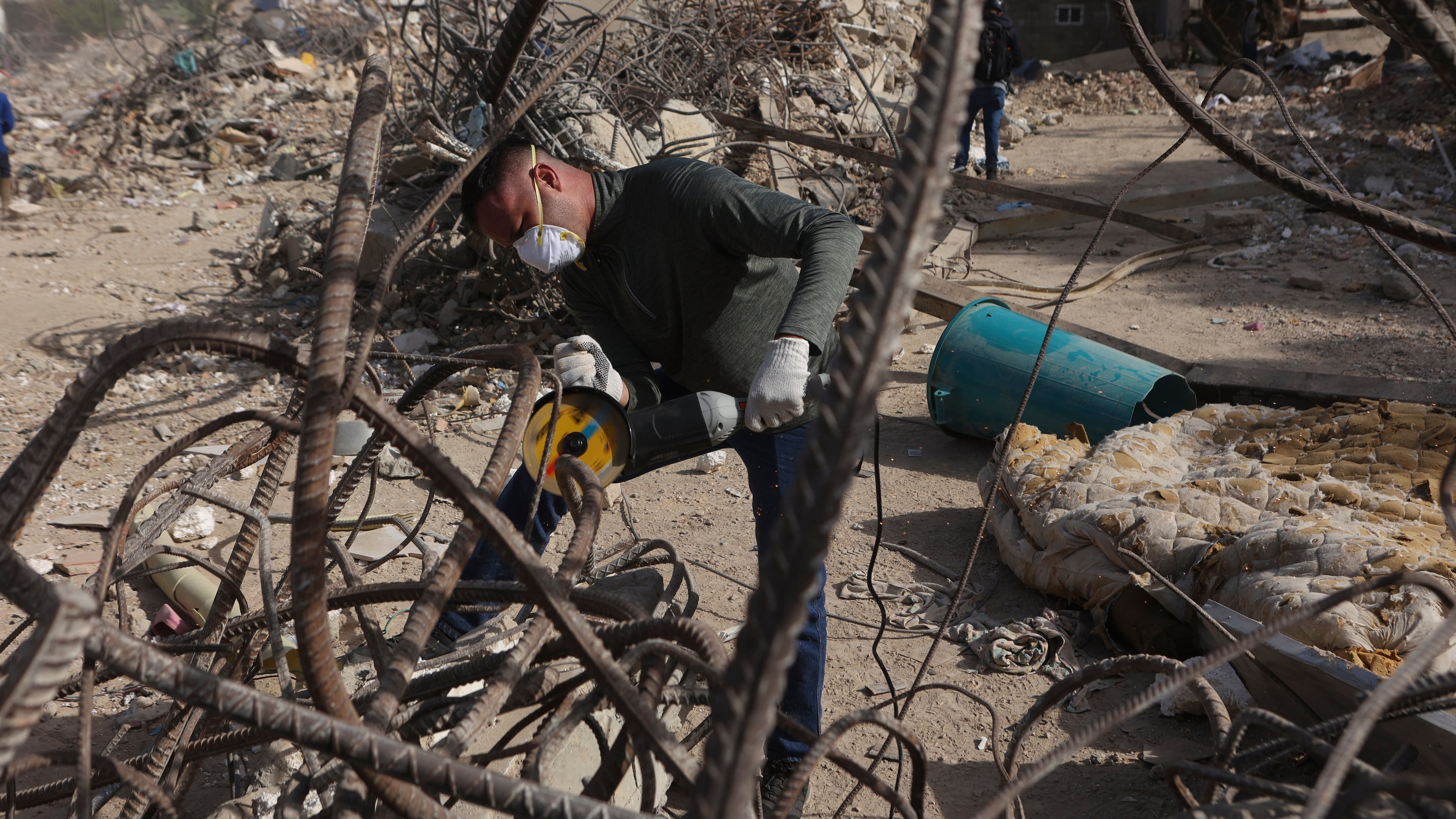 FILE - A worker cuts rebar from an an O-P-P housing tower that was built as part of a government program, and collapsed during twin earthquakes in La Guaira, Venezuela, July 25, 2026. (AP Photo/Pedro Mattey, File)