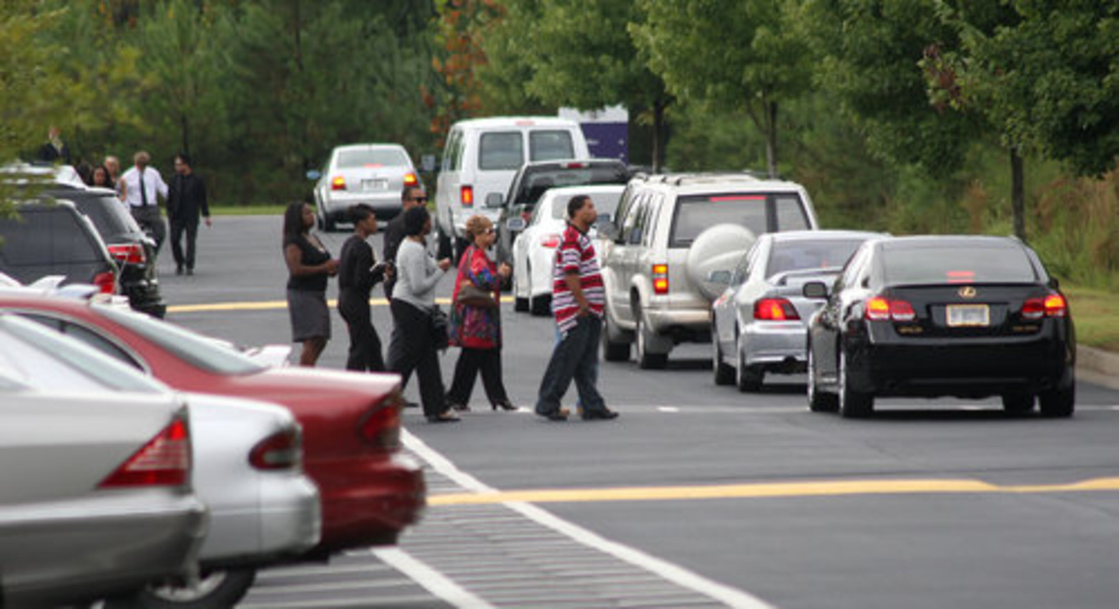 Visitors make their way from the parking lot to the church to attend the funeral for NFL Denver Broncos' wide receiver Kenny McKinley at Word of Faith Family Worship Cathedral in Austell Monday, Sept. 27, 2010.