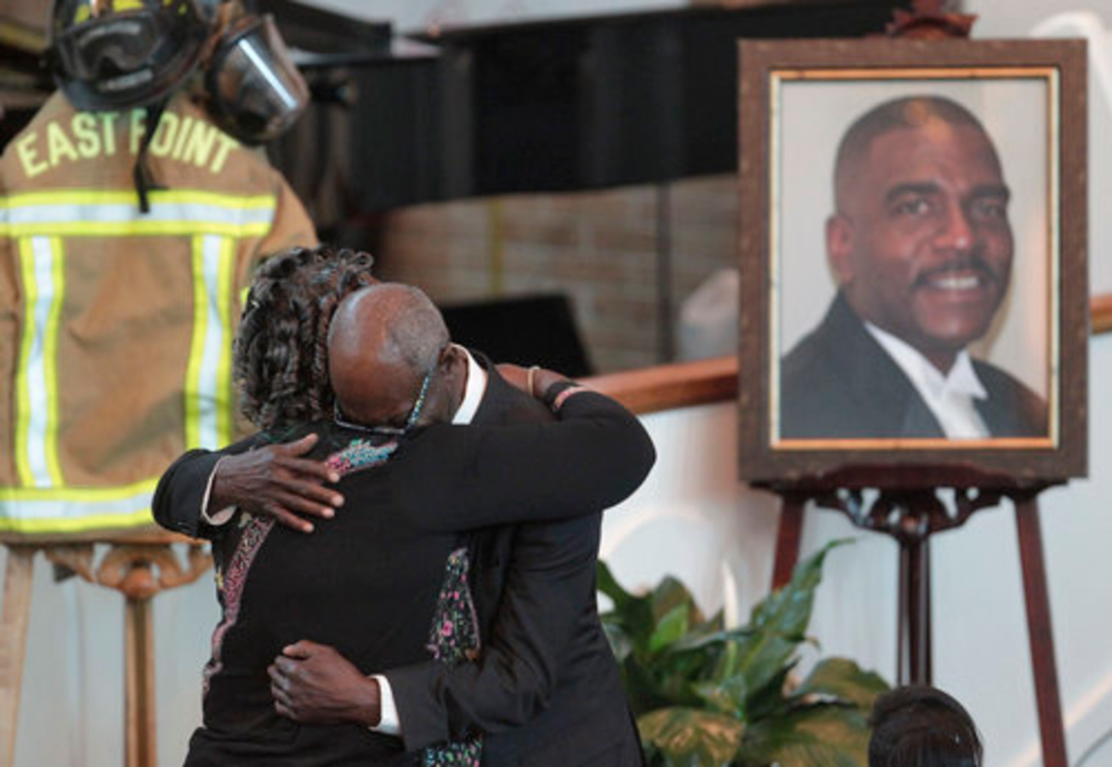 Carl Blake's uncle, Carlton Wood, or "Uncle Carlton" as he called himself, who said Carl was his namesake, hugs a family member after making remarks.