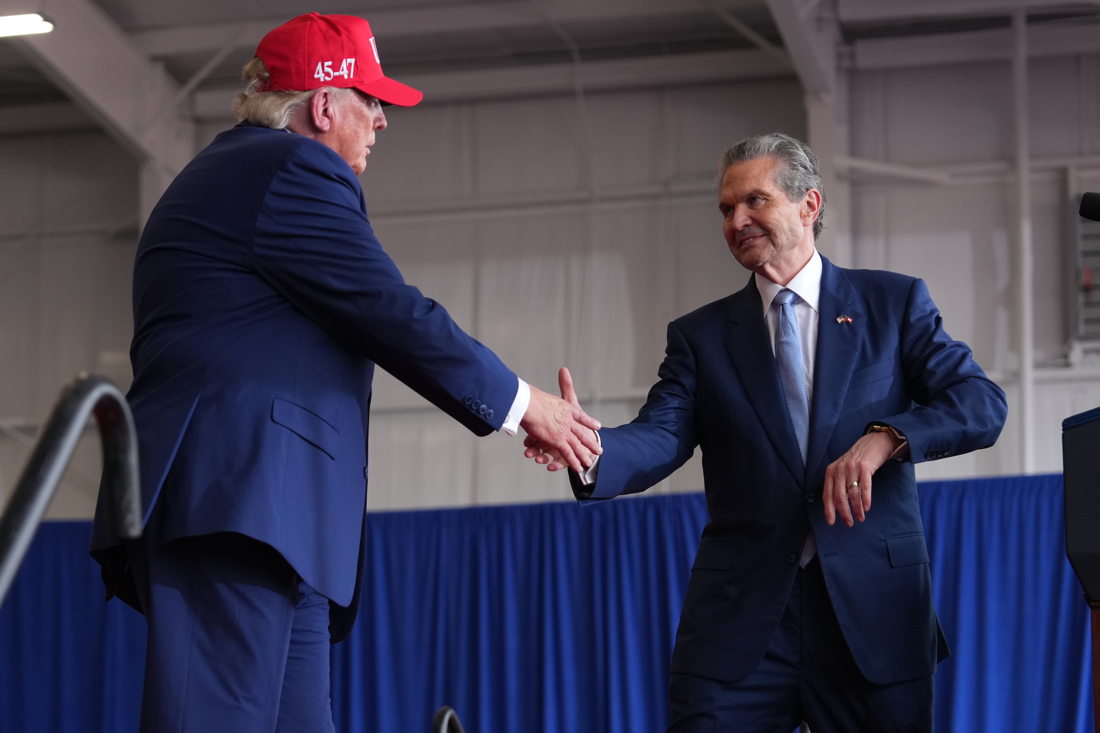 President Donald Trump (left) shakes hands with Republican nominee for governor Rick Jackson at a campaign rally at Dalton Municipal Airport on Friday. (Mark Schiefelbein/AP)
