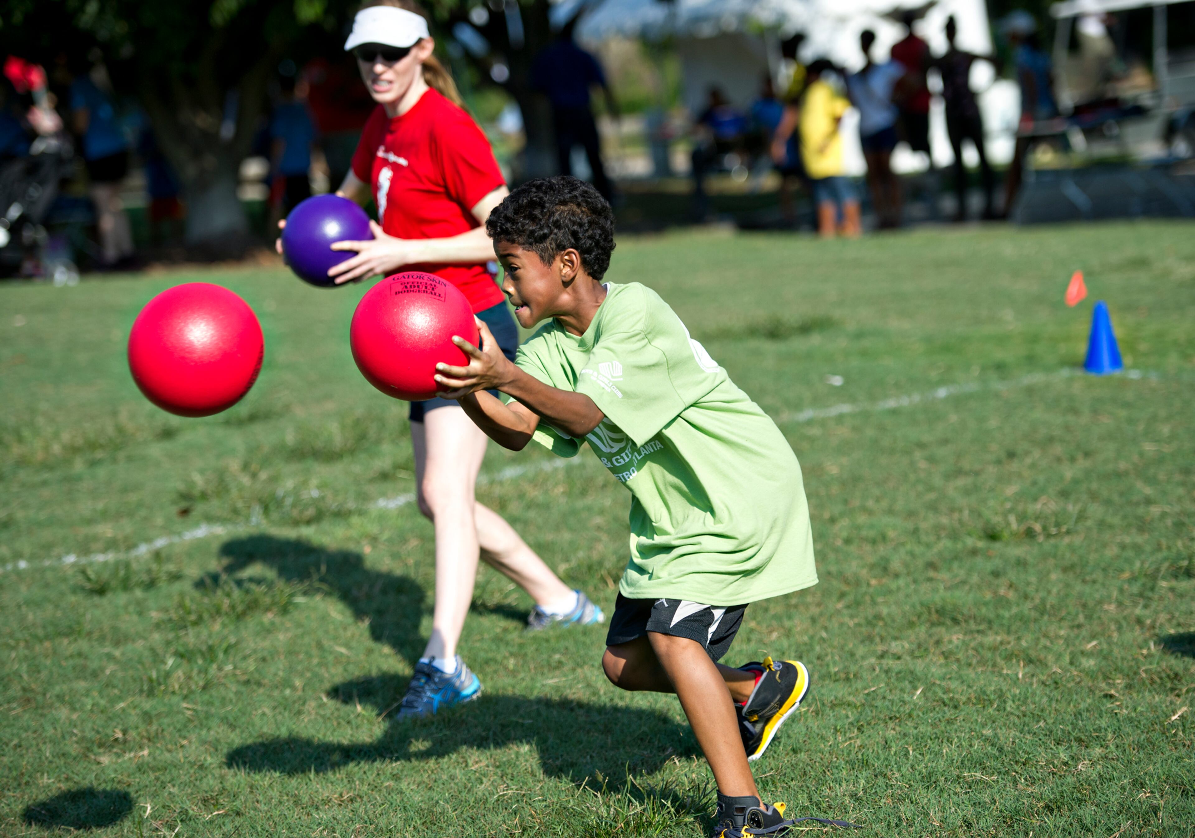 Kobe Jackson (right) useshis ball to block another one as he plays a game of dodgeball with Melissa Gwinn during the Boys & Girls Clubs of America's Day for Kids at Piedmont Park in Atlanta on Saturday, September 7, 2013. Day for Kids is a national initiative to raise awareness for critical issues facing young men and women. With more than a decade of tradition, Day for Kids invites adults to act like kids again by participating in field day events such as relay races, dodge ball, tug of war and lots of other activities. JONATHAN PHILLIPS / SPECIAL