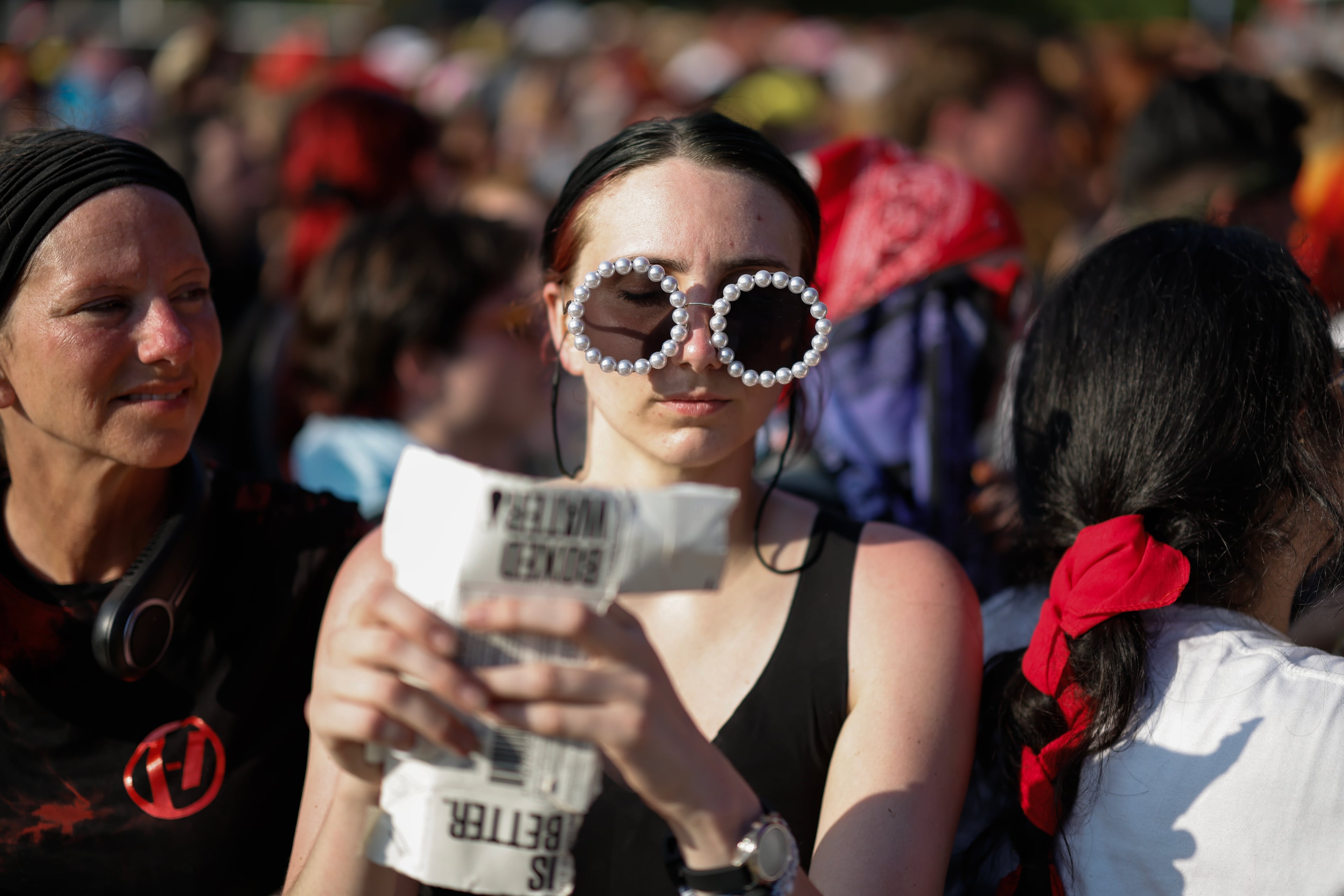 A fan listens to Peach Pit perform during the Shaky Knees music festival at Piedmont Park, Saturday, Sept. 19, 2026, in Atlanta. (Erik S. Lesser for the AJC)