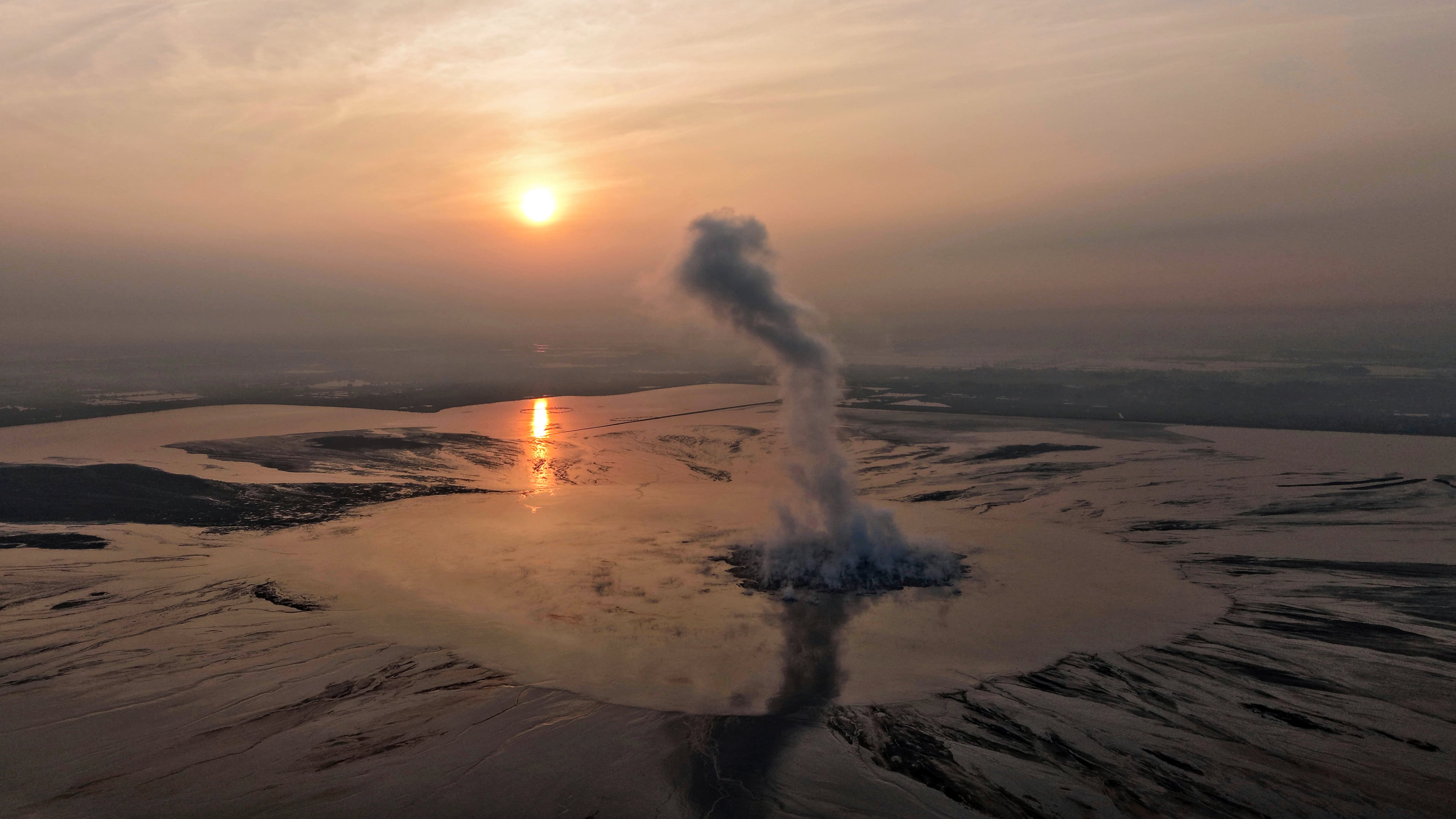 Smoke billows from the crater of the "mud volcano" that was caused by a gas exploration accident in 2006, in Sidoarjo, East Java, Indonesia, Friday, May 29, 2026. (AP Photo/Trisnadi)