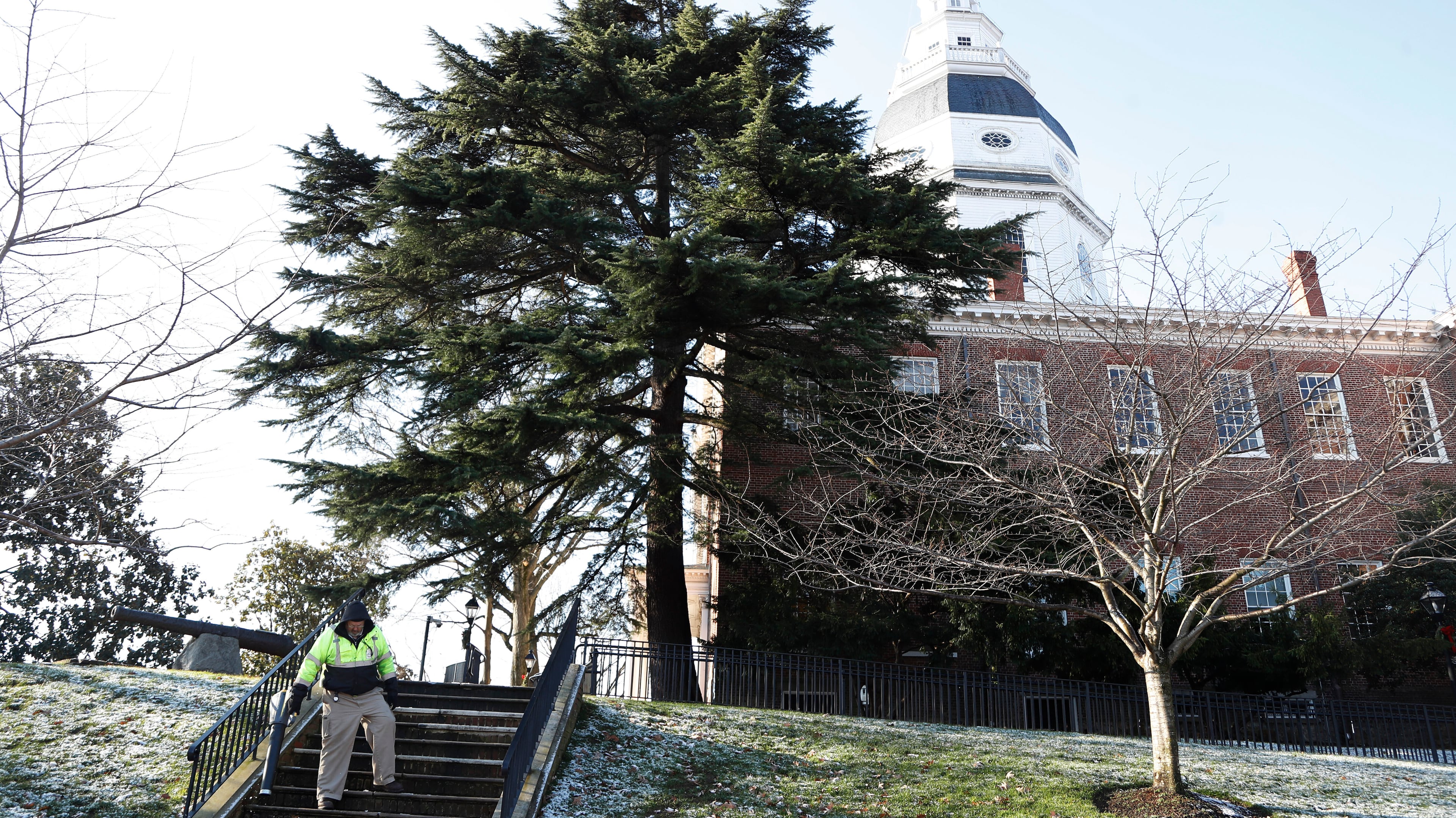 FILE - A worker blows leaves and snow off steps outside of the Maryland Statehouse on, Wednesday, Jan. 8, 2020, in Annapolis, Md. (AP Photo/Julio Cortez, File)