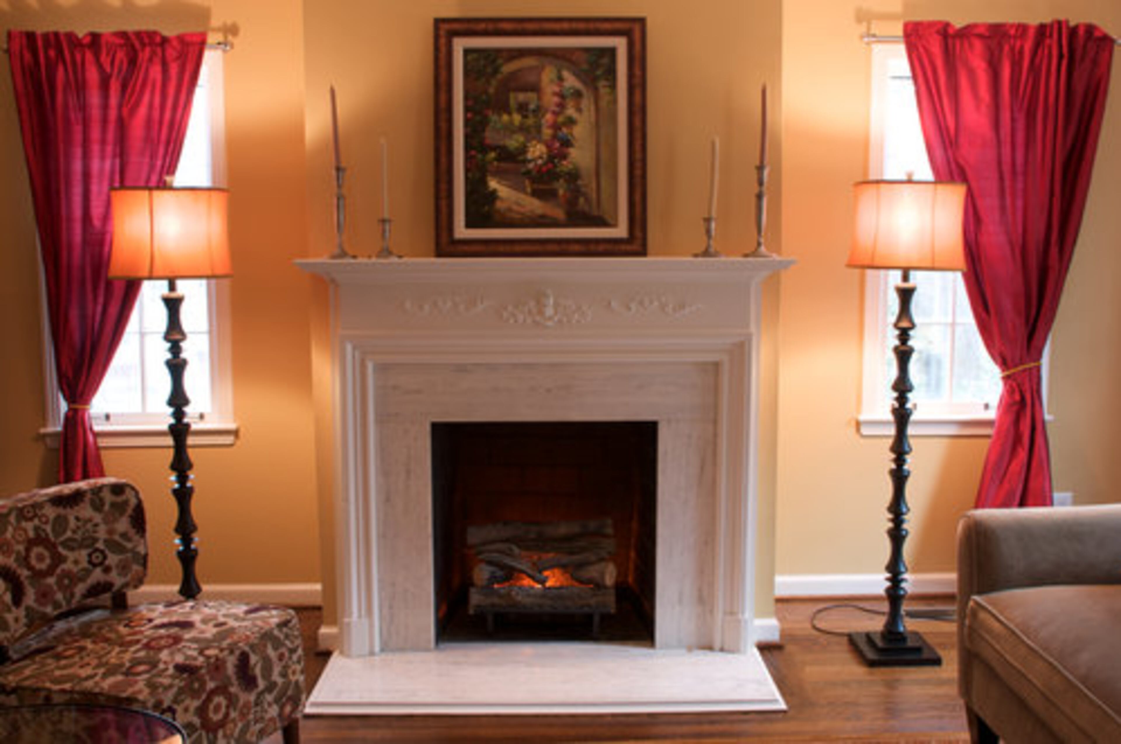 White marble surrounds the fireplace. The painting above the mantle was purchased in Piazza Novella during a family vacation to Rome, Italy.