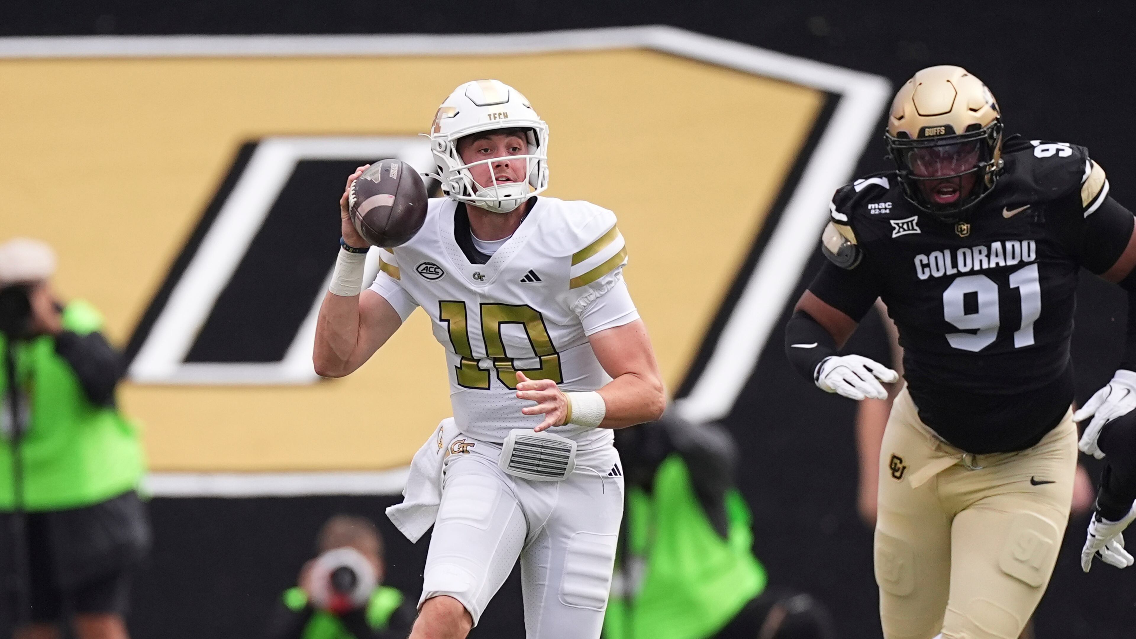 Georgia Tech quarterback Haynes King, left, looks to pass the ball as Colorado defensive end Brandon Davis-Swain pursues in the first half of an NCAA college football game Friday, Aug. 29, 2025, in Boulder, Colo. (AP Photo/David Zalubowski)