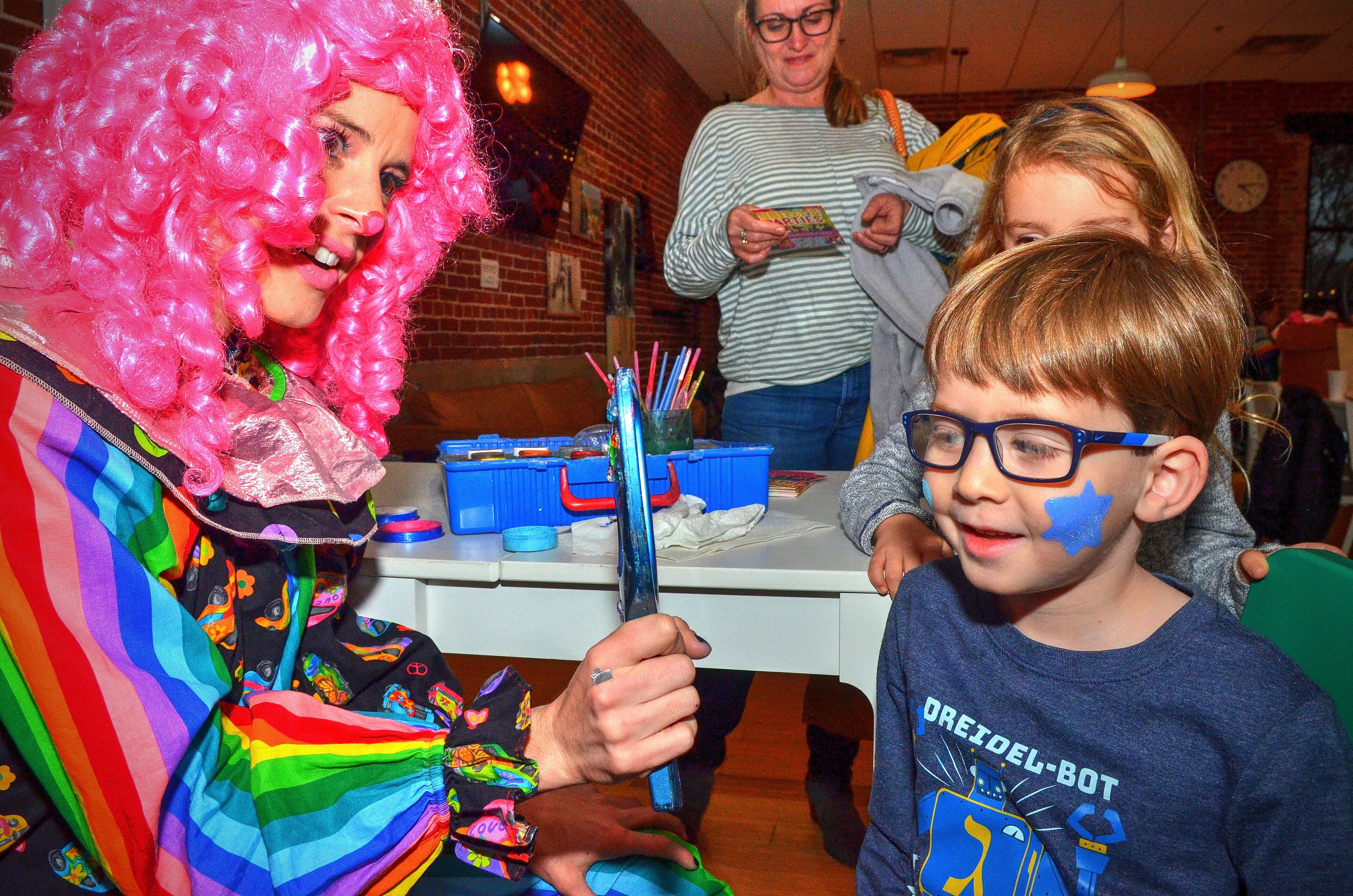 191222 Atlanta, Ga: Mason Poncz likes his Star of David face paint by Britzy the Clown. Menorah lighting and celebration sponsored by Chabad Intown and MJCAA Day Camps. Music, entertainment, Dreidels, doughnuts, hot latkes, gelt drop and more. Children who RSVP will recieve and Chanukah gift. All photos taken Sunday 12/22/2019 at Chabad Intown, along the Beltline in Atlanta, Ga. (Photo credit Chris Hunt Photography) for 122319hanukkah