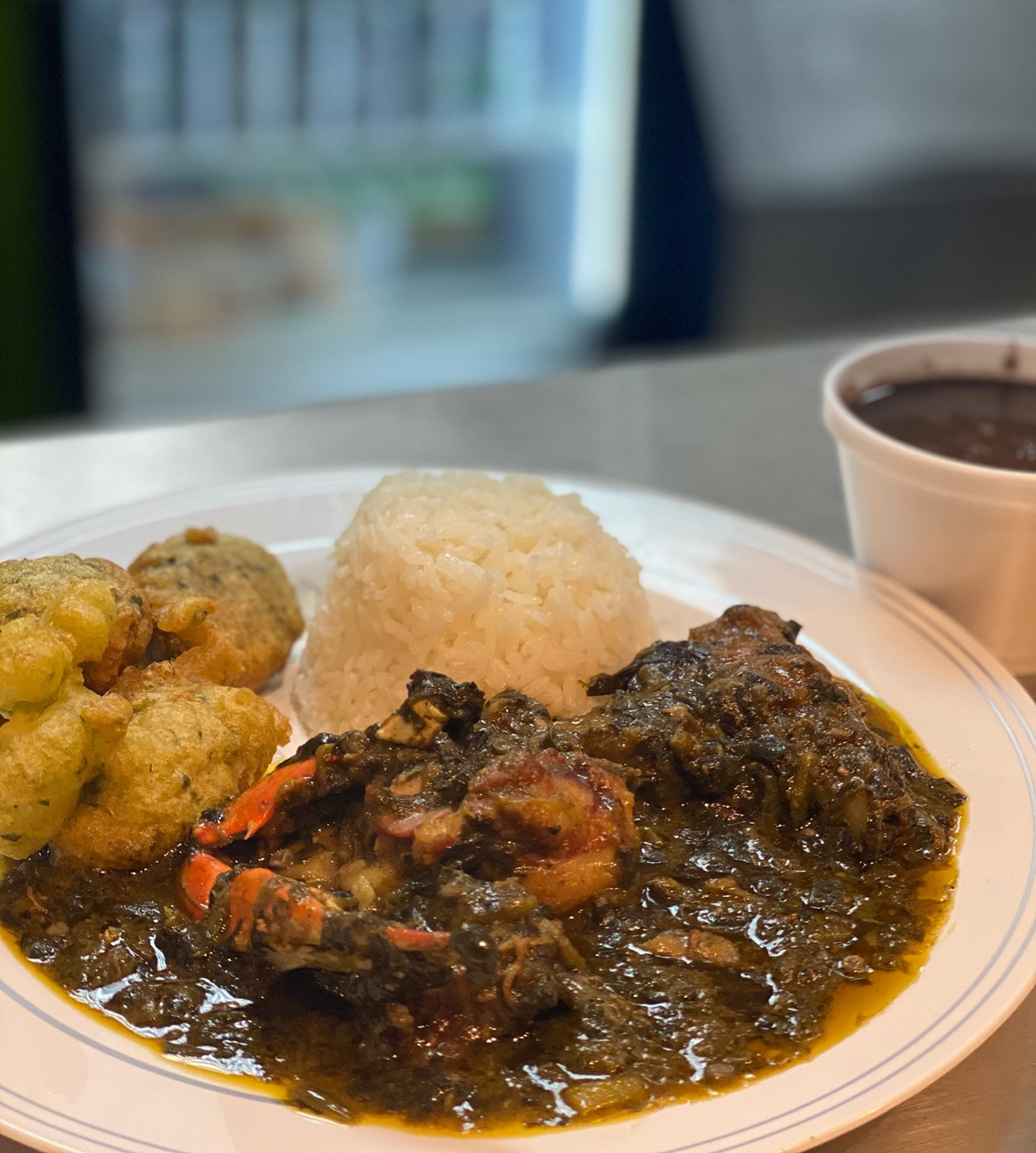 Jojo Fritay serves lalo, a Haitian stew of crab, pork and jute and spinach leaves, shown here with marinad fritters, white rice and black beans. Lalo means jute.
Courtesy of Tercy Ugens Toussaint