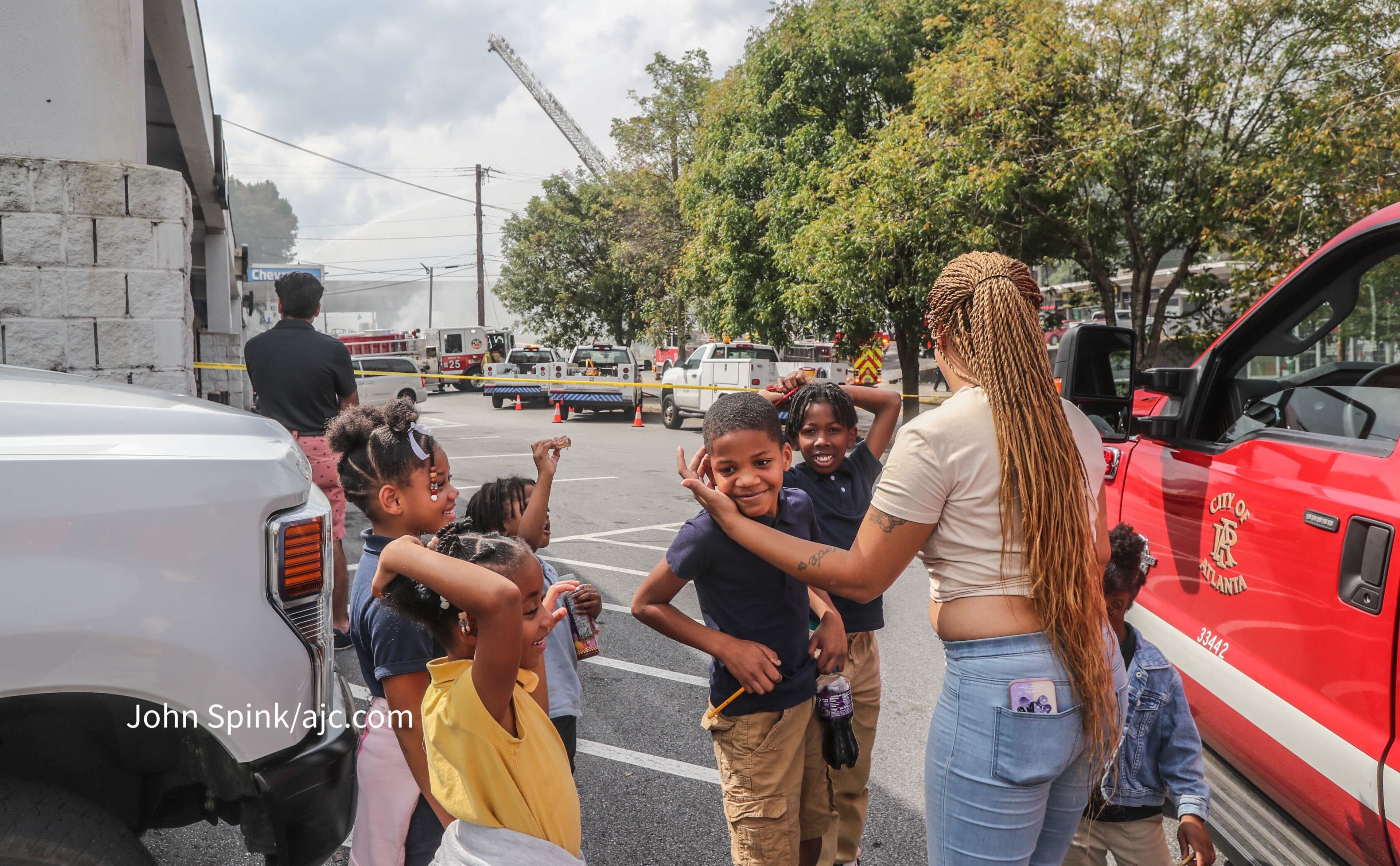 Tinesha Teasley, along with her children and young family members watch the fire from a safe distance on Wednesday.