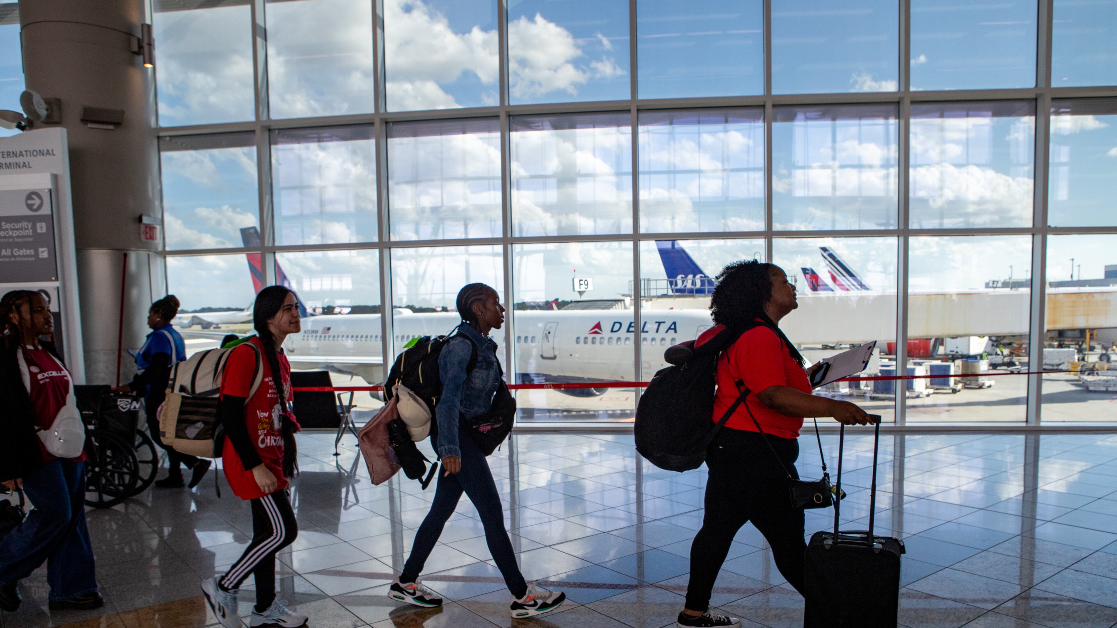 Atlanta Public Schools teacher Stephanie Jones, right, leads students toward security at Hartsfield-Jackson Atlanta International Airport on Saturday, April 5, 2025, on their way to Spain for their spring break. APS partners with Xperitas, an immersion program where select high school students travel abroad, live with other students, go to school with them and experience the culture. (Jenni Girtman for The Atlanta Journal-Constitution)