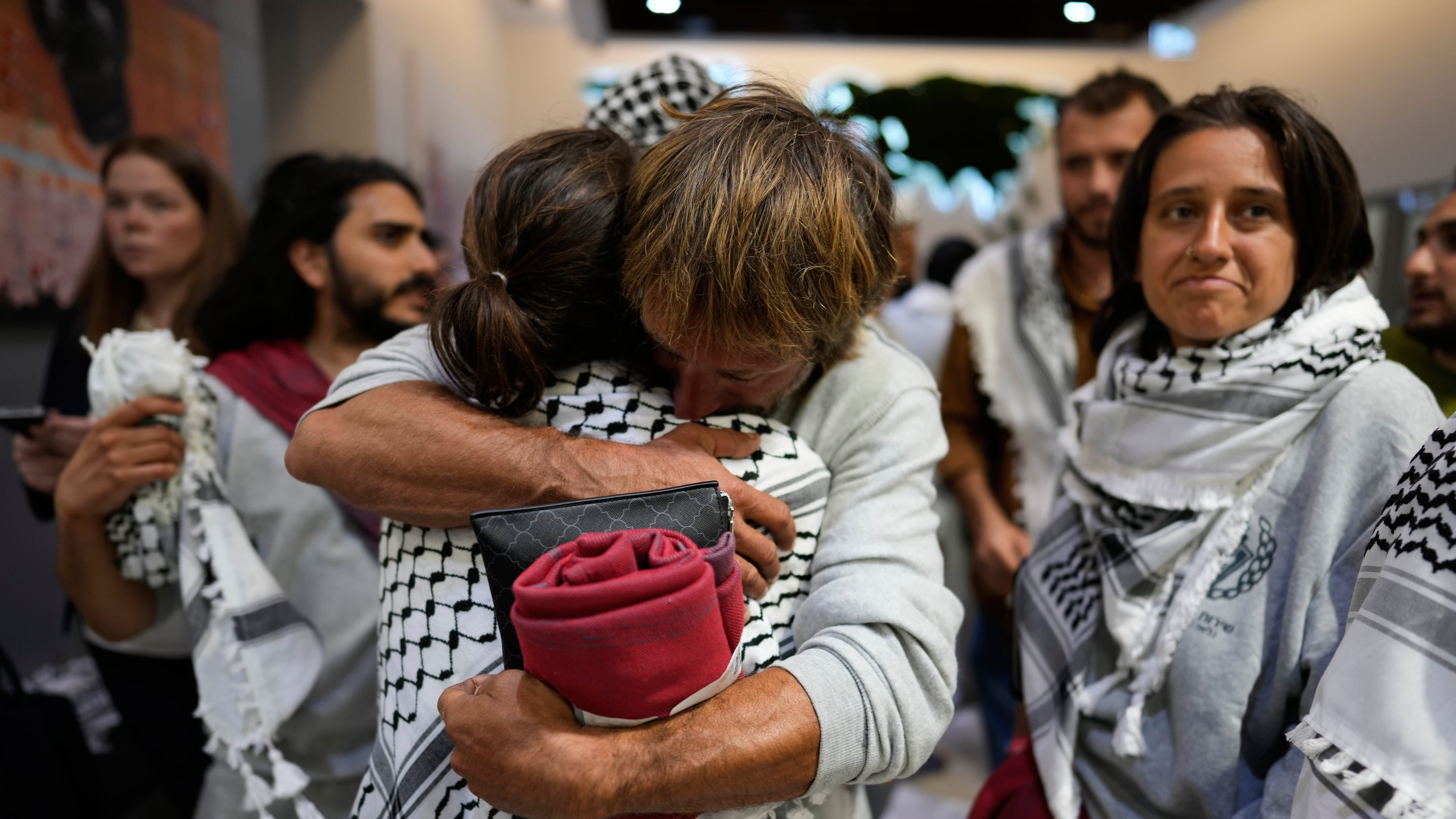 Activists from the Global Sumud Flotilla comfort each other upon their arrival at Istanbul Airport, in Istanbul, Turkey, Thursday, May 21, 2026. (AP Photo/Emrah Gurel)