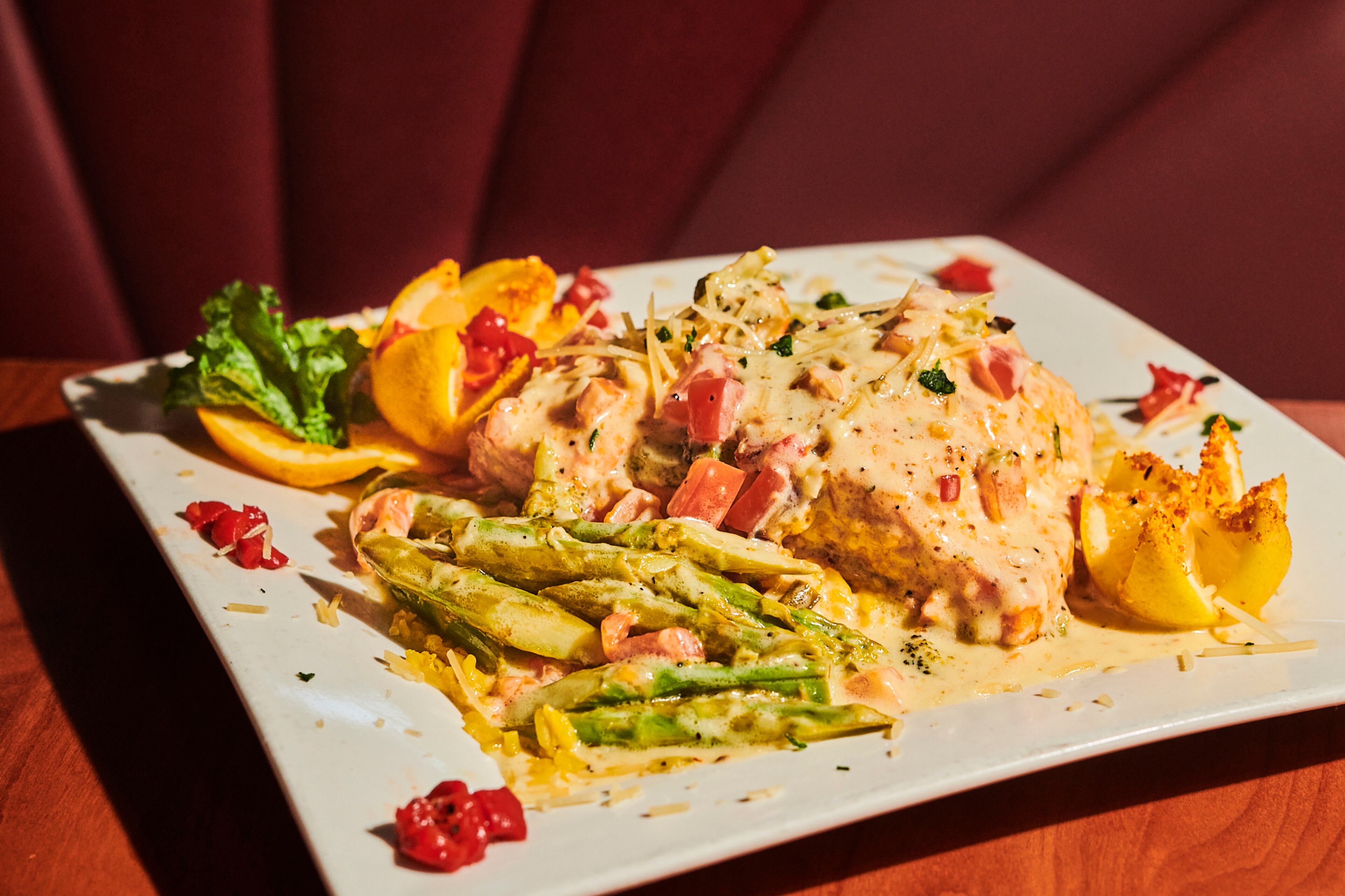 Salmon Charlotte at the Marietta Diner includes broiled, stuffed salmon, studded with basil, garlic, peppers and onions, and topped with white wine butter and olive oil. It's served over rice, with asparagus and broccoli. (Greg Rannells for The Atlanta Journal-Constitution)