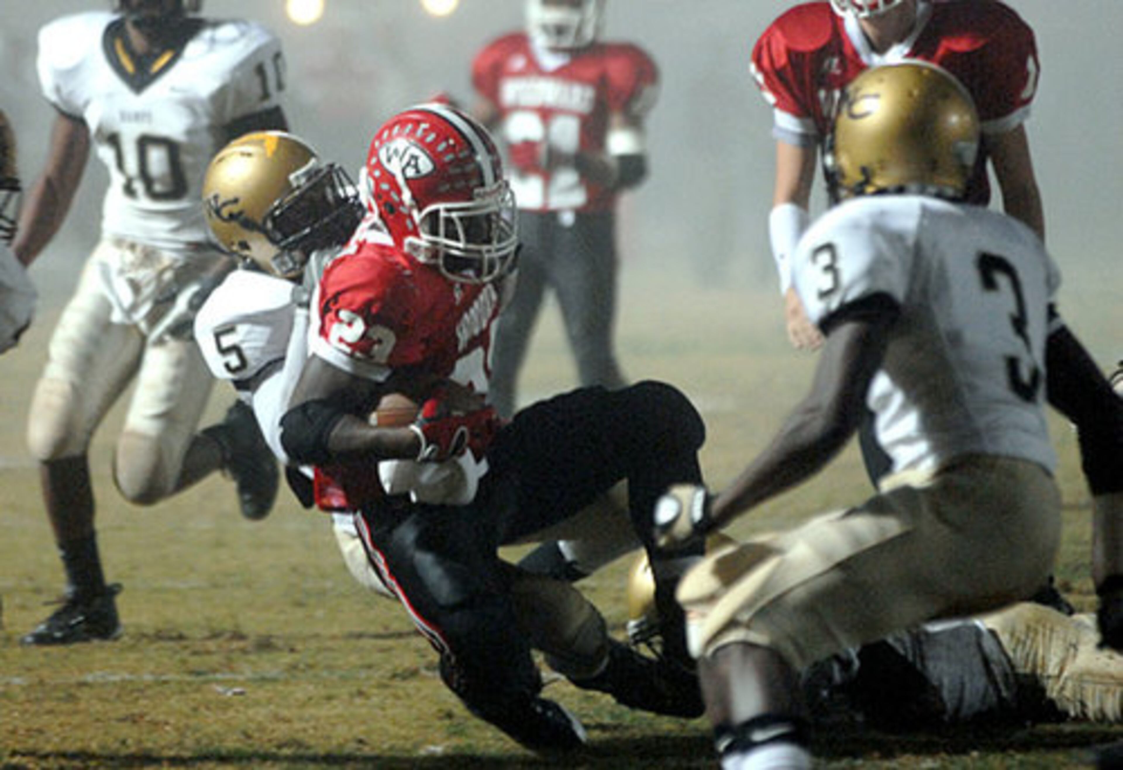 Woodward Academy's Juwan Thompson (No. 23) is wrapped up by Washington County's Raheem Marshall (No. 5) near the end zone.