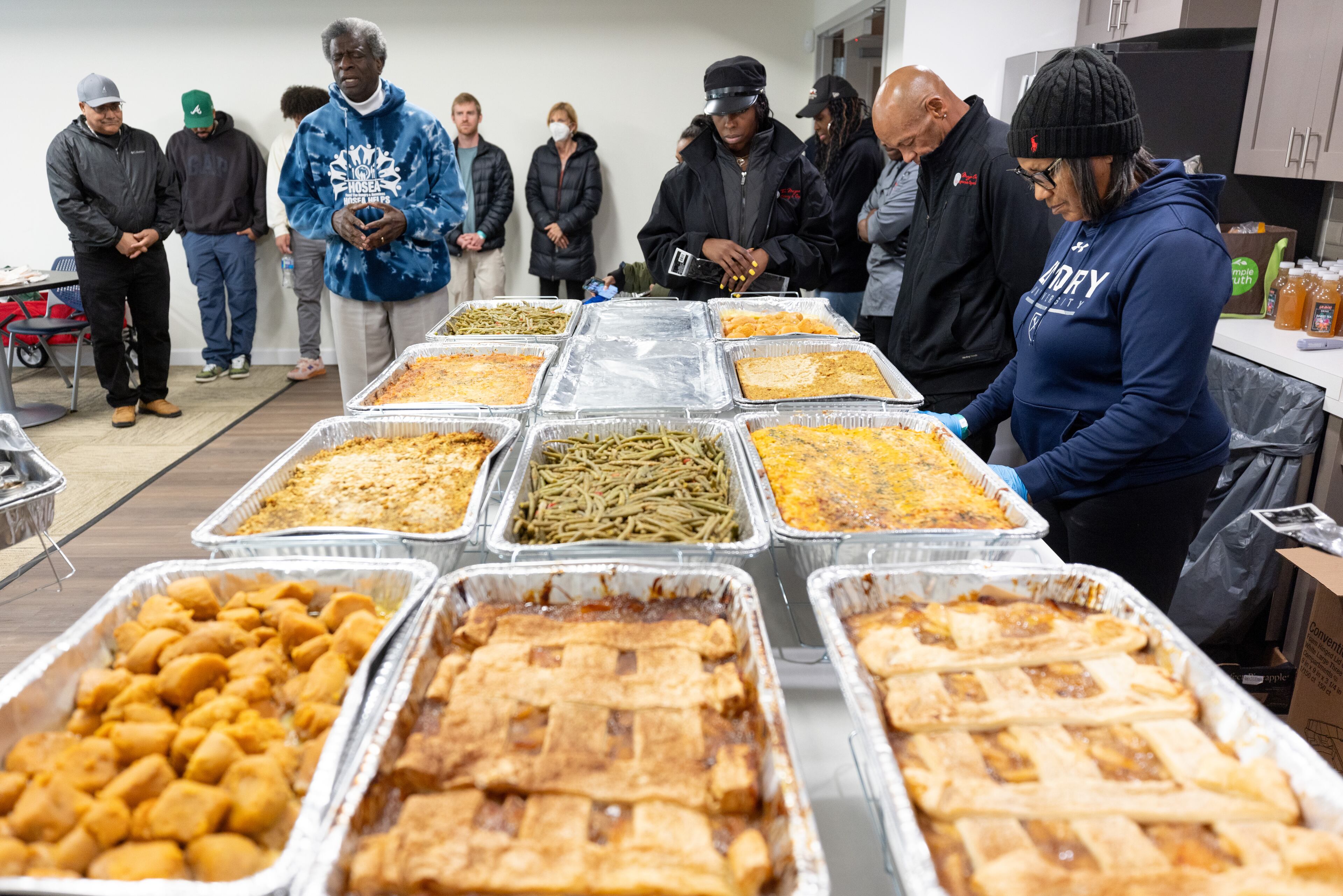 Actor Afemo Omilami says a prayer over the Thanksgiving day meals delivered to the James Allen Jr Place Apartments in Atlanta on Thursday, Nov. 23, 2023. Through a vast volunteer network, Hosea Helps prepared and delivered 1200 hot meals Thursday to people around Atlanta. (Steve Schaefer/steve.schaefer@ajc.com)