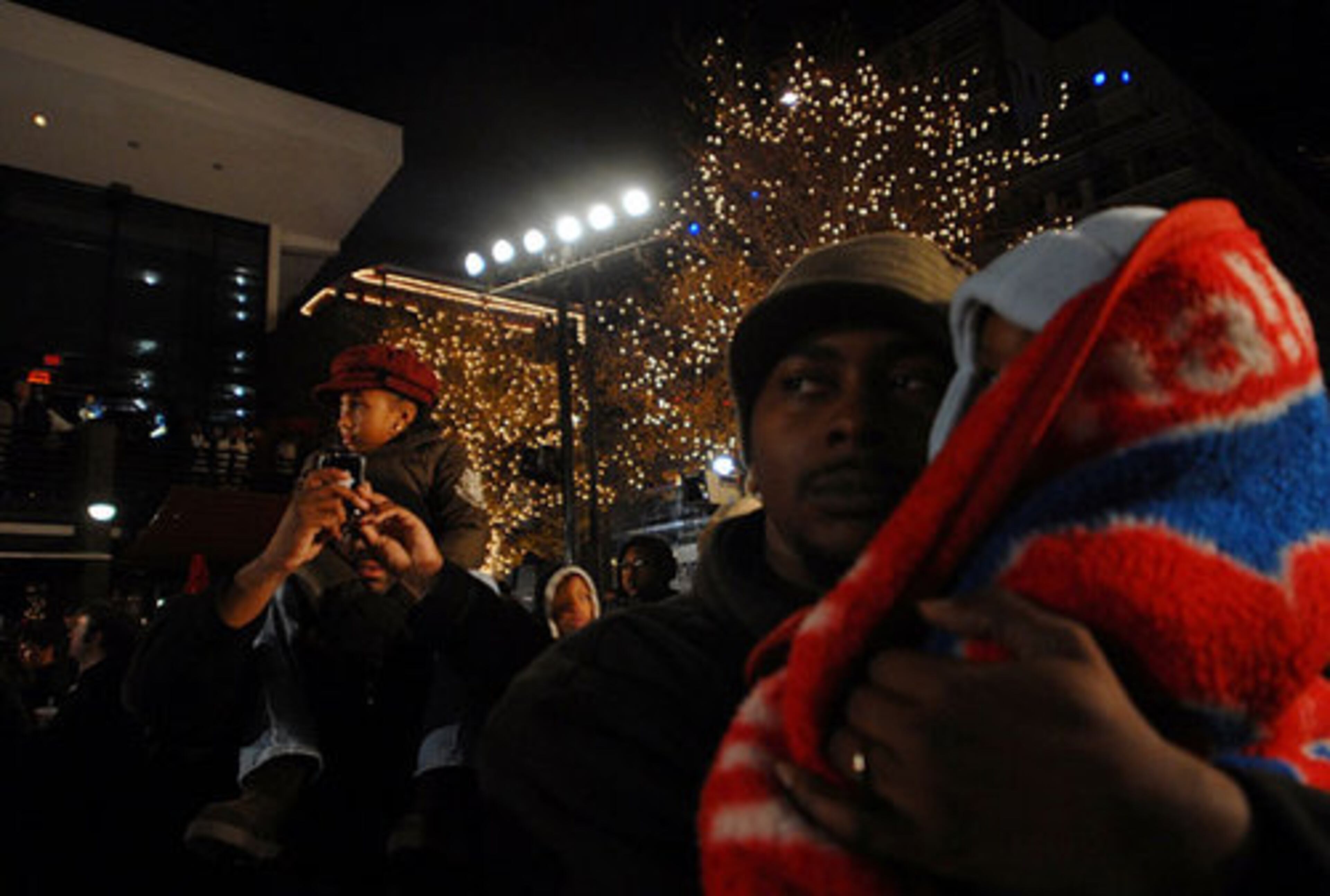 Wayne Pleasant takes a picture of himself and his daughter, Danielle, 8, while Jahmal Harris holds his eight-month-old son, Tristan.