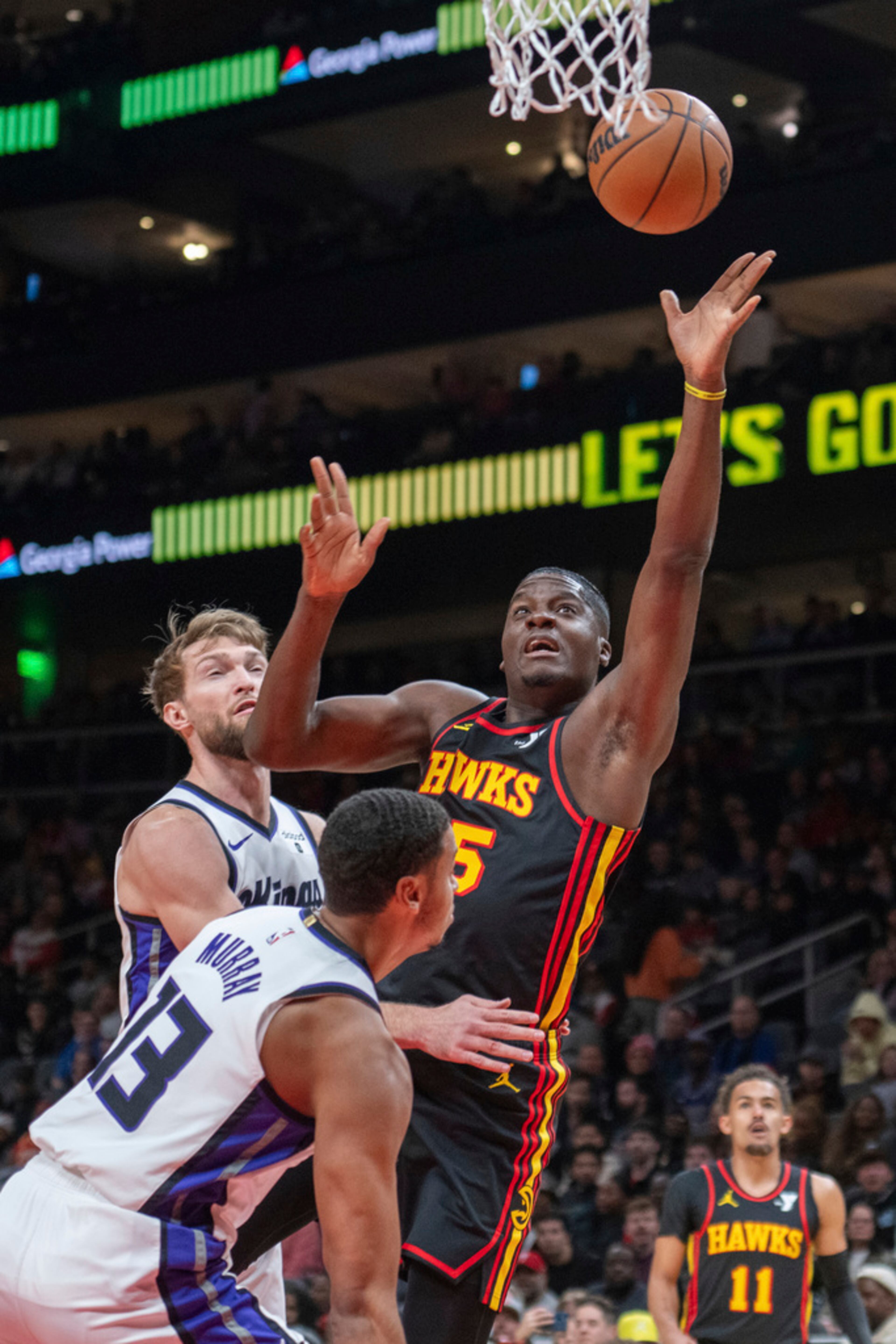 Atlanta Hawks center Clint Capela (15) shoots between Sacramento Kings forward Domantas Sabonis (10) and forward Keegan Murray (13) during the first half of an NBA basketball game Friday, Dec 29, 2023, in Atlanta. (AP Photo/Hakim Wright Sr.)