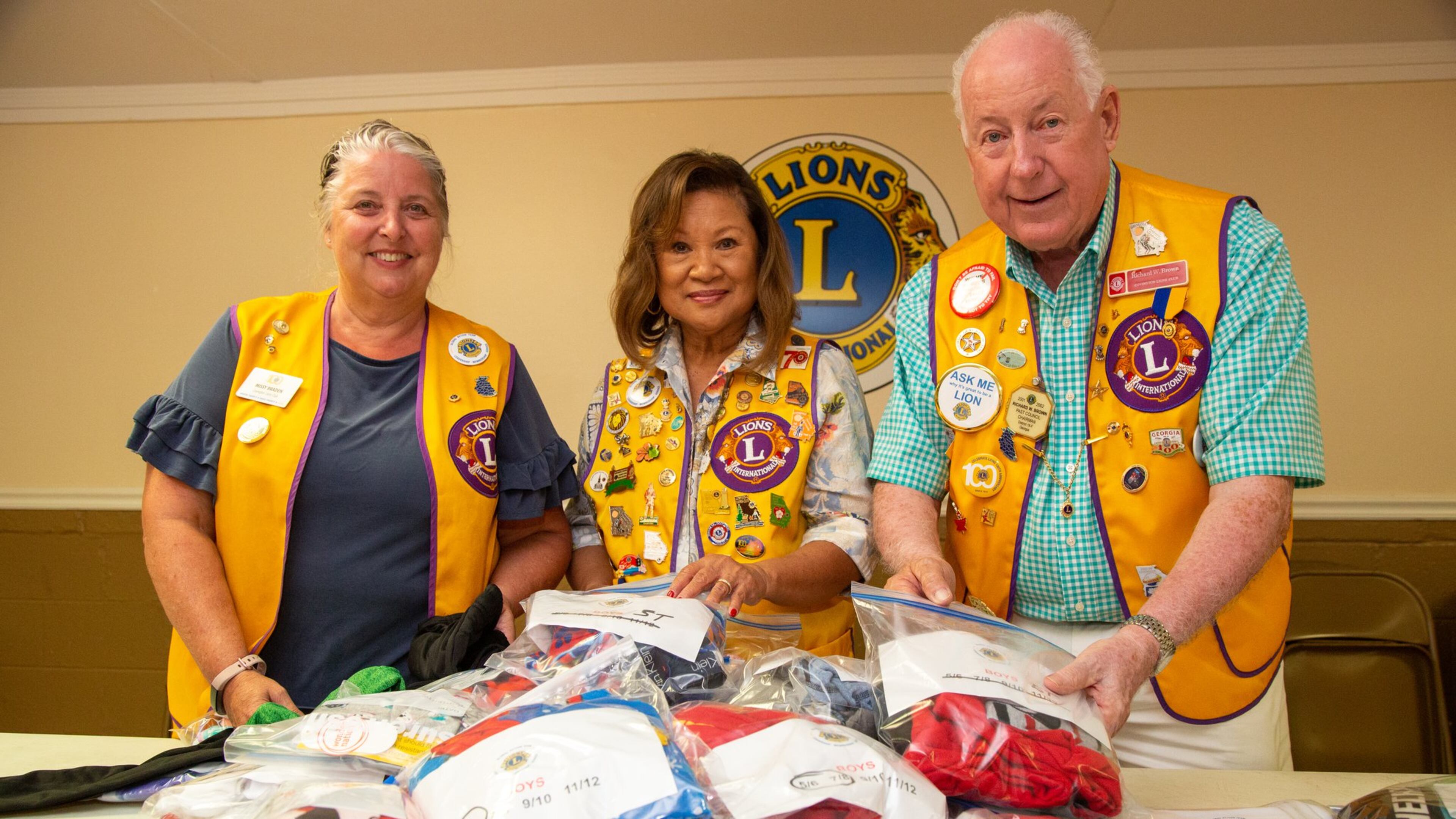 Missy Braden (from left), Doreen Stallworth, Richard Brown fill “PJ Packs” with new PJs, underwear and socks during a meeting of the Georgia Lions Club in Covington. Stallworth came up with a service project of giving “PJ Packs” to hospitalized children at Children’s Healthcare of Atlanta. (Photo by Phil Skinner)