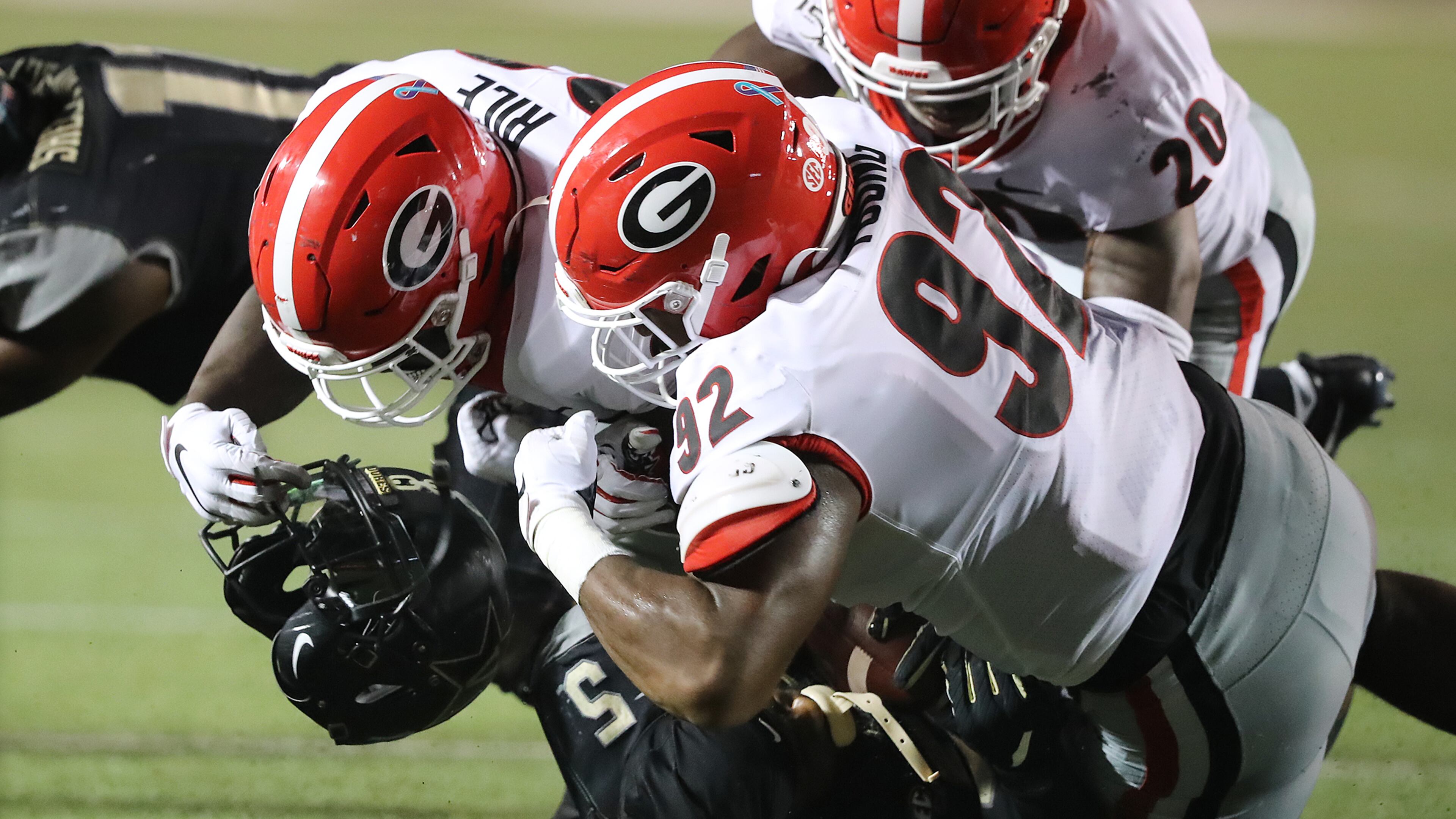 August 31, 2019 Nashville: Georgia defensive end Justin Young (right) rips the helmet off Vanderbilt ball carrier Ke'Shawn Vaughn on a tackle but is called for a personal foul during the second quarter in a NCAA college football game on Saturday, August 31, 2019, in Nashville. Curtis Compton/ccompton@ajc.com