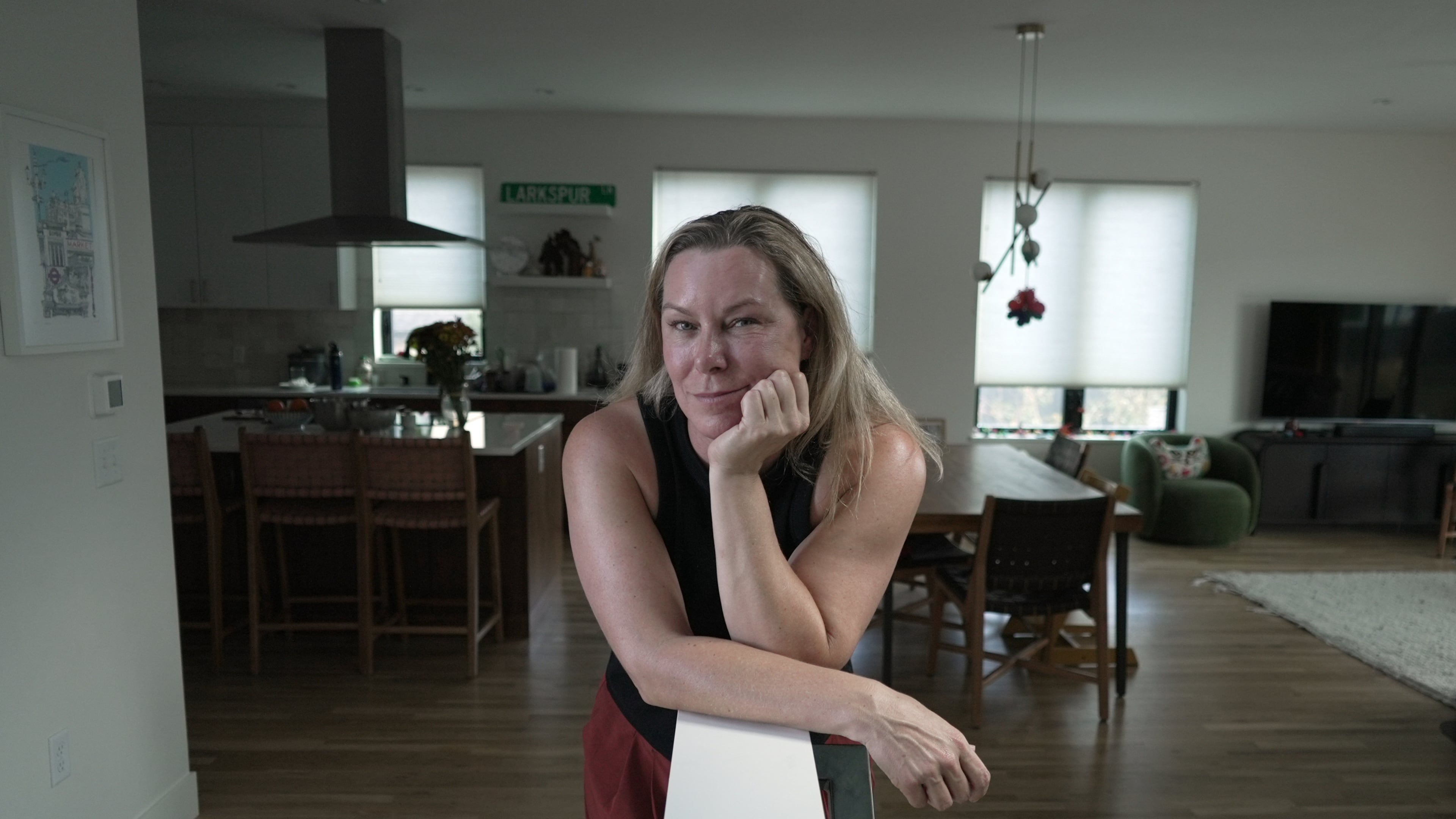 Tawnya Somauroo leans on a ledge in her new fire-resilient home, Monday, Sept. 21, 2026, in Louisville, Colo. (AP Photo/Brittany Peterson)