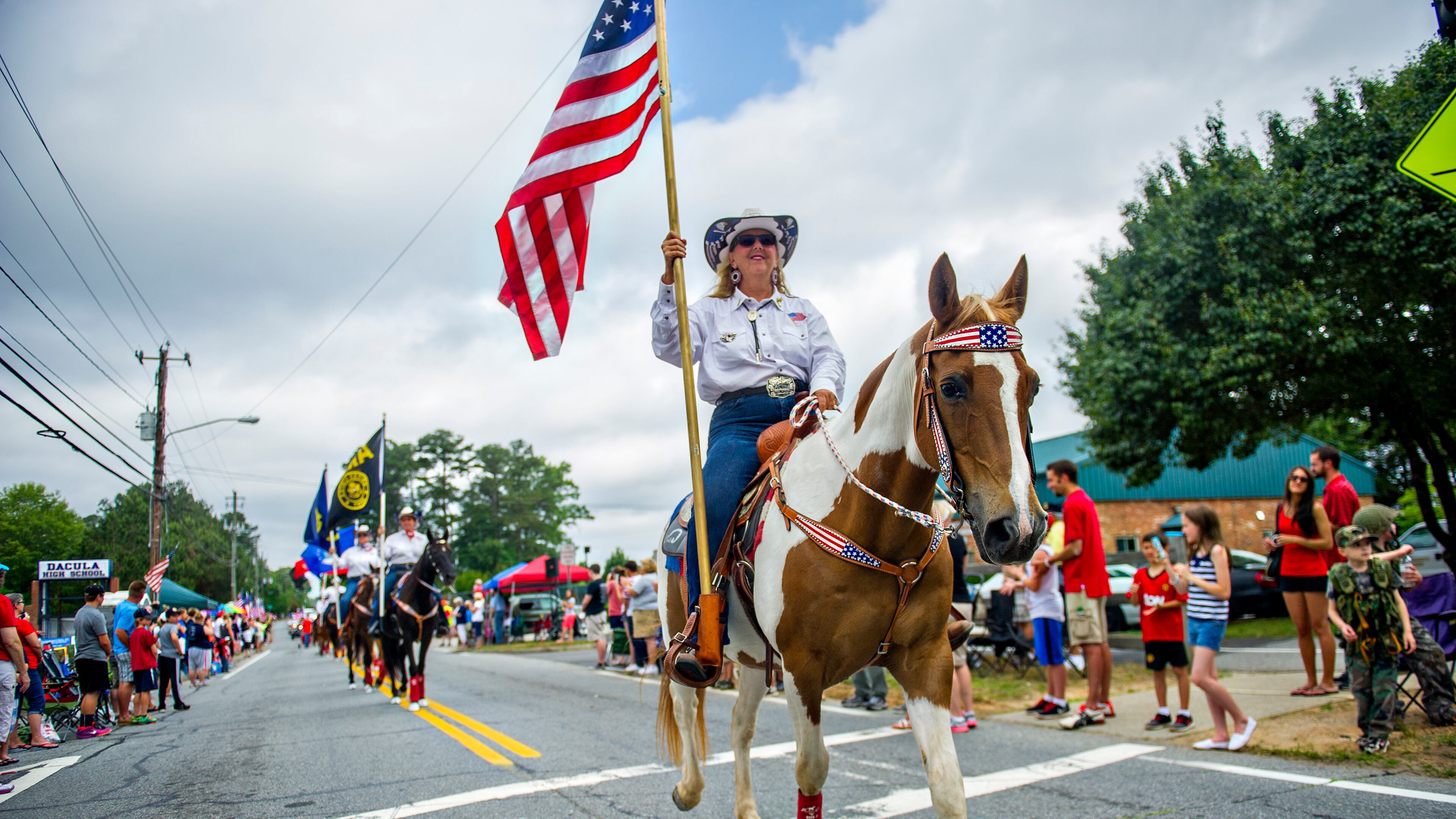 Ann Harris carries an American flag down Dacula Rd. while on horseback during the 2015 Dacula Memorial Day Parade. The parade, now in its 24th year, remains the only Memorial Day parade in Metro Atlanta, largest in the the state of Georgia and one of the largest in the nation with more than 150 units participating this year. JONATHAN PHILLIPS / SPECIAL
