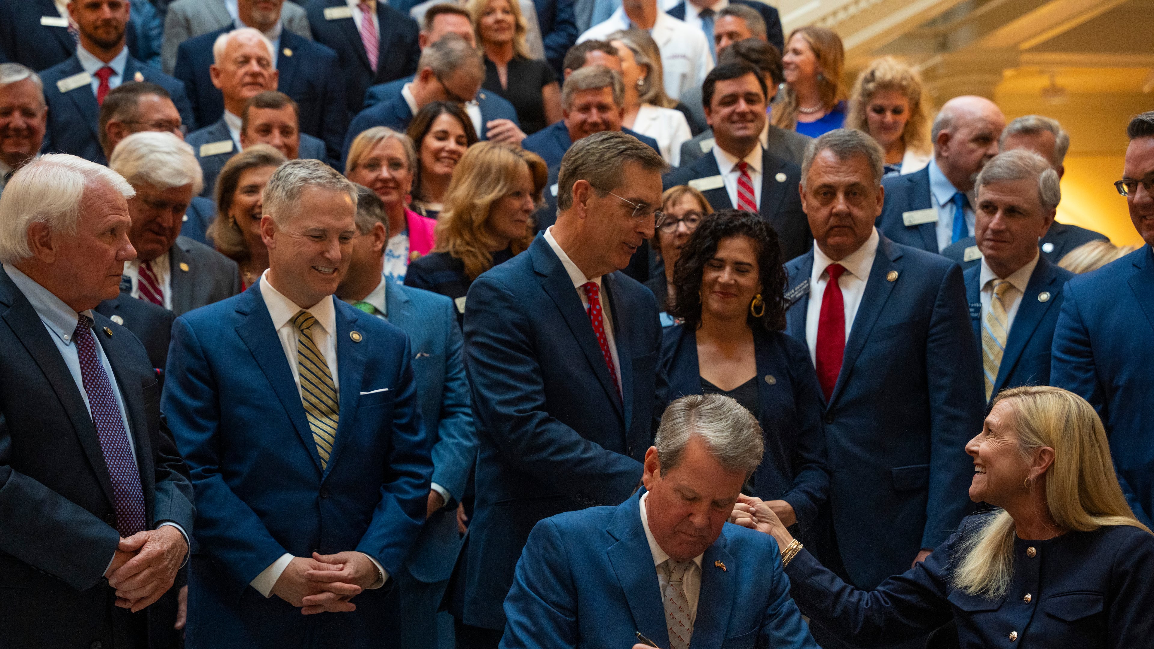 Gov. Brian Kemp signs SB 68 and SB 69 into law alongside first lady Marty Kemp during a press conference at the Georgia Capitol. (Olivia Bowdoin for the AJC 2025)
