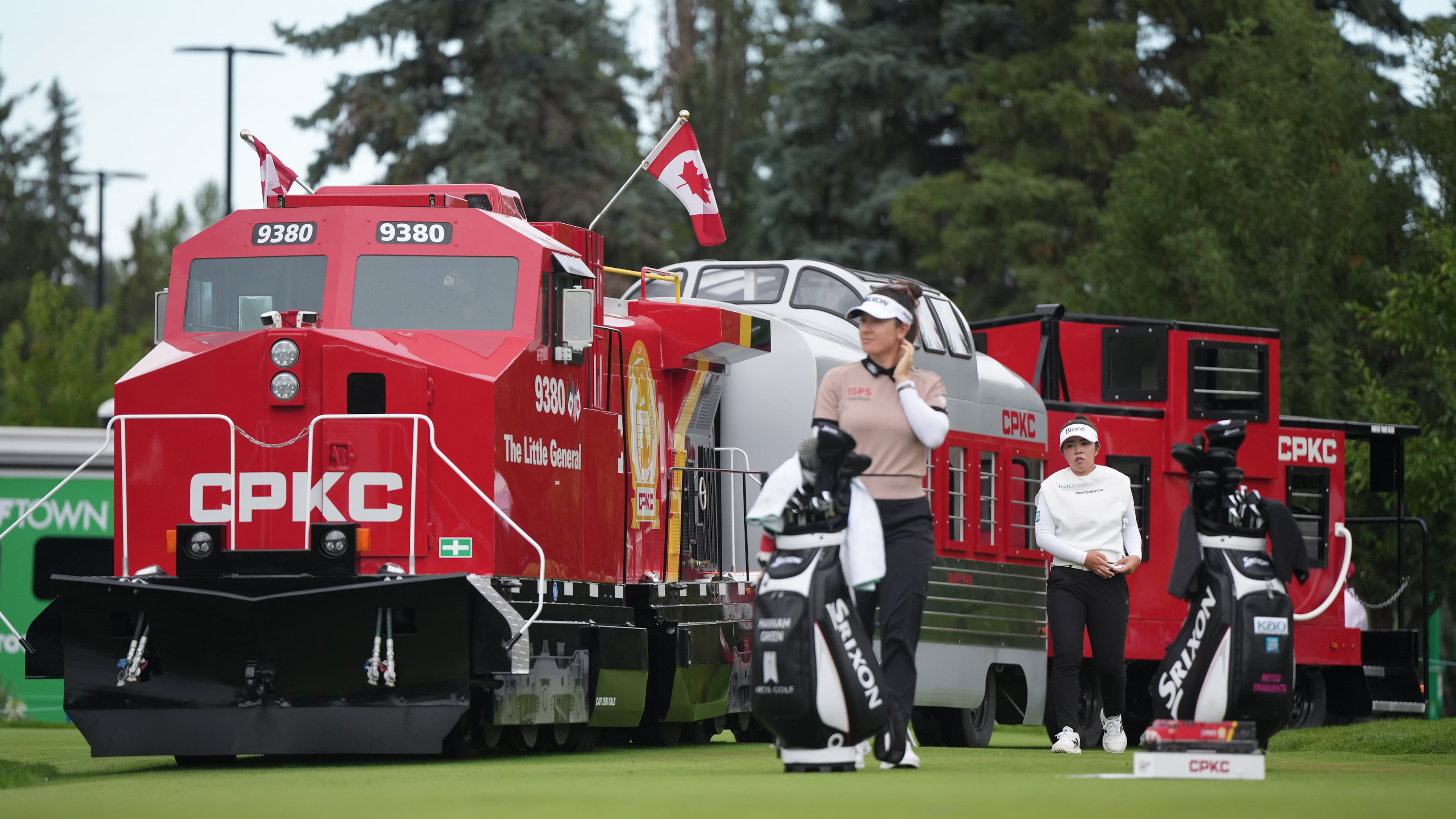 Miyu Yamashita, back right, of Japan, walks past a mini CPKC train as she arrives at the first tee behind Hannah Green, of Australia, during the first round at the LPGA Canadian Women's Open golf tournament in Edmonton, Alberta, Thursday, Aug. 20, 2026. (Darryl Dyck/The Canadian Press via AP)