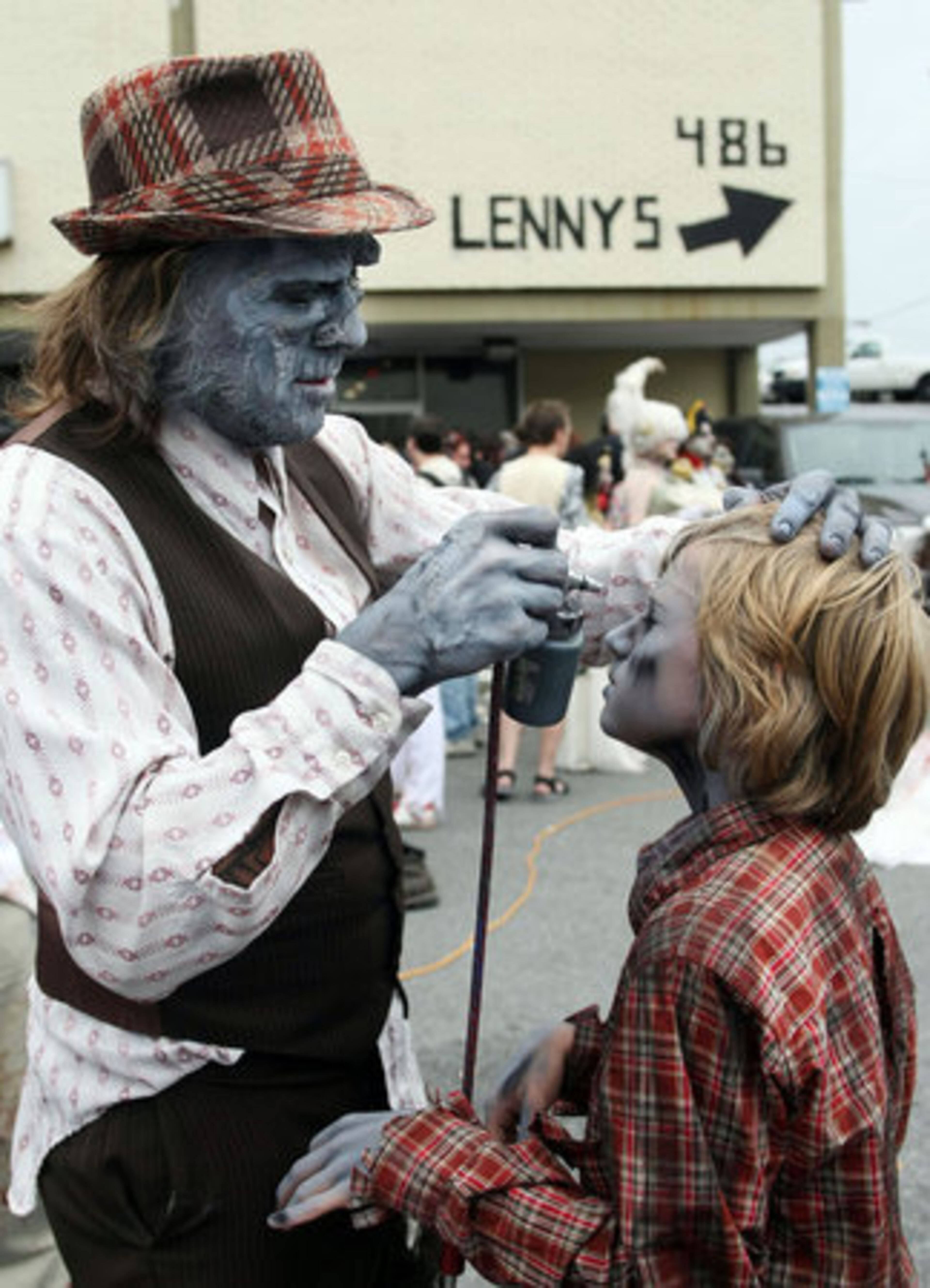 Shane Morton (left) puts finishing ghoul touches 13-year-old Eddie Mumma's face.