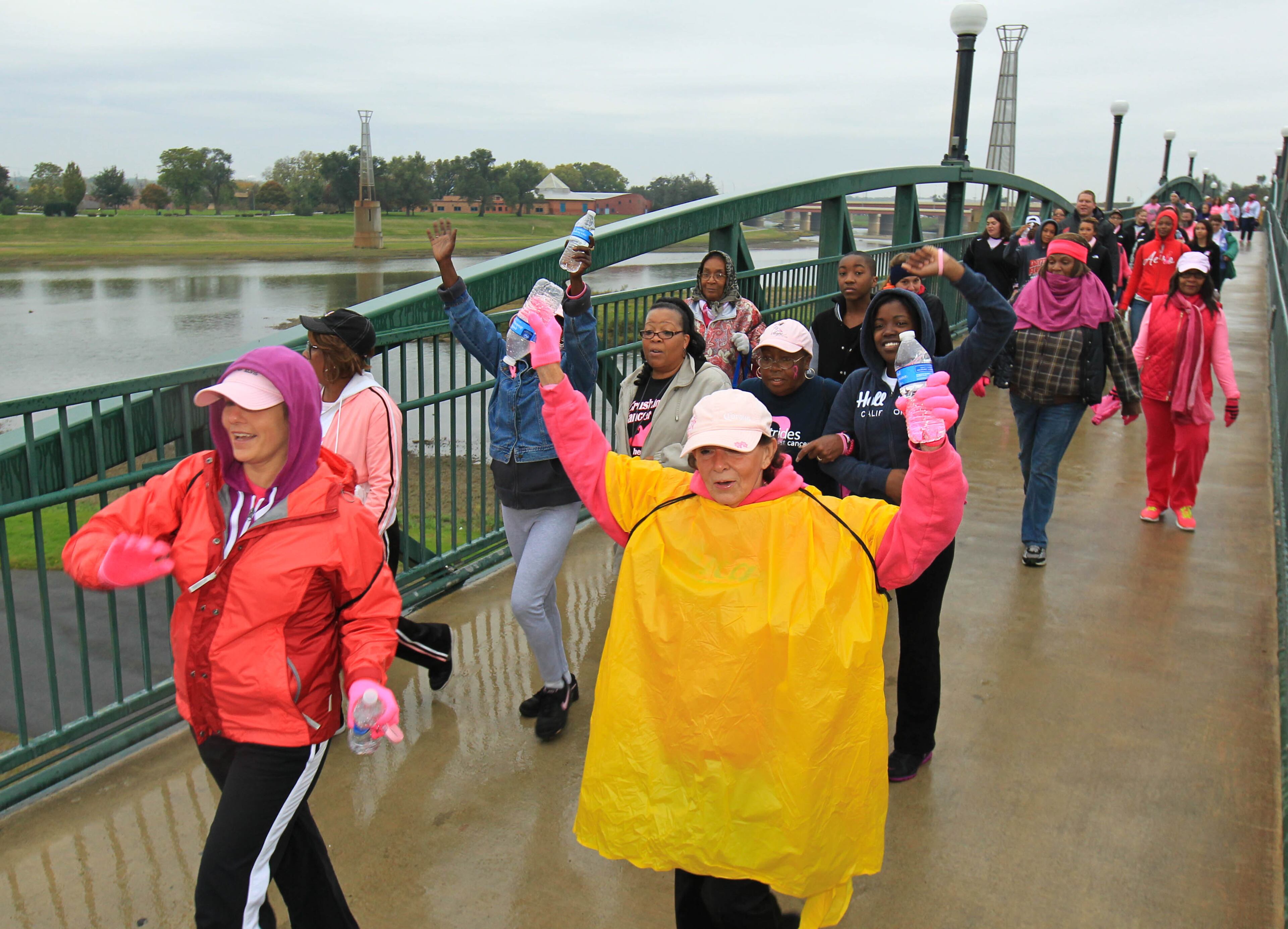 Despite the rainy conditions, participants show enthusiasm along the route at the Making Strides Against Breast Cancer Walk in Dayton at Fifth Third Field Saturday morning. JIM WITMER / STAFF
