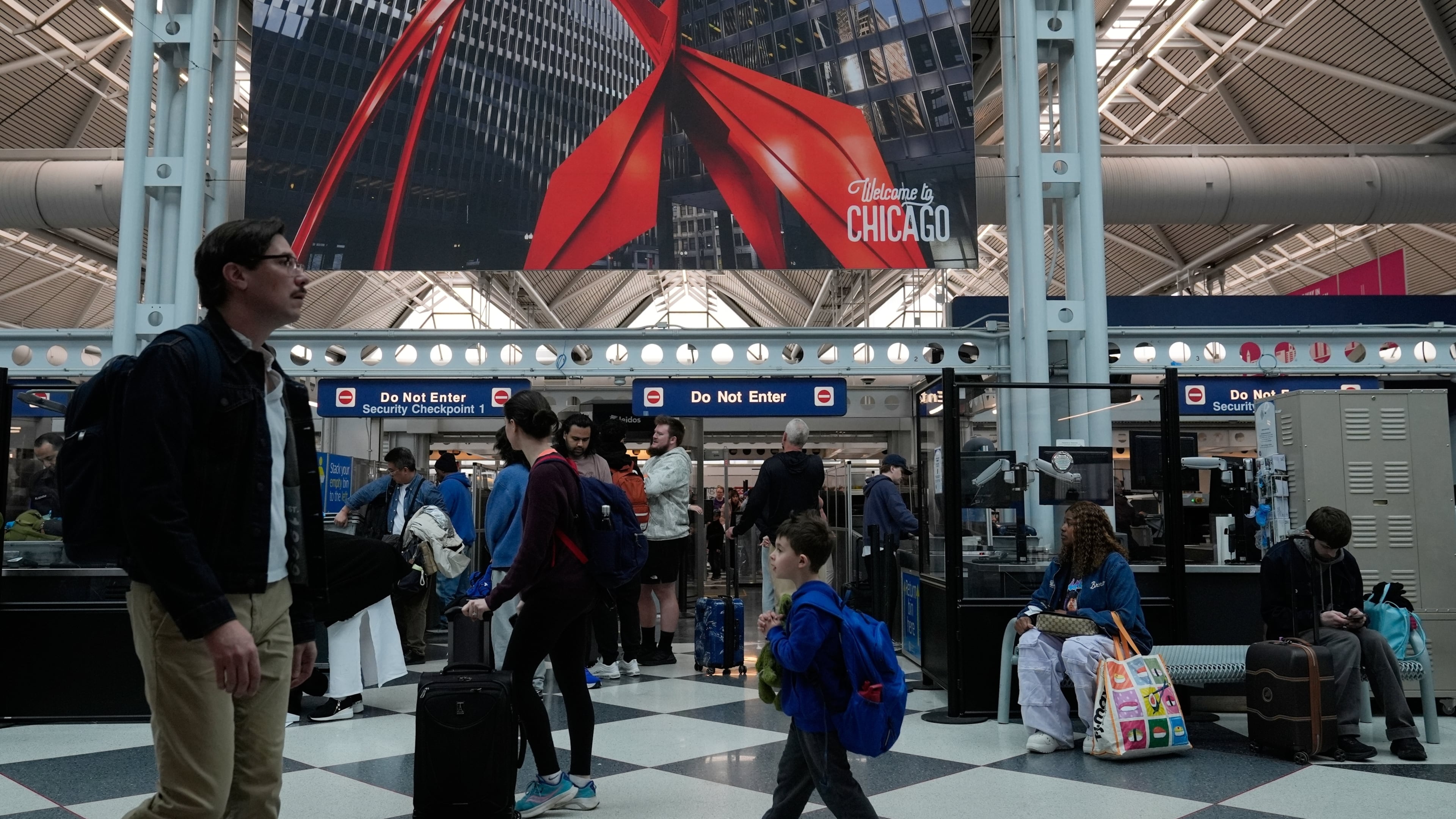 Travelers go through TSA security check at O'Hare International Airport, Saturday, March 21, 2026, in Chicago. (AP Photo/Kiichiro Sat0)