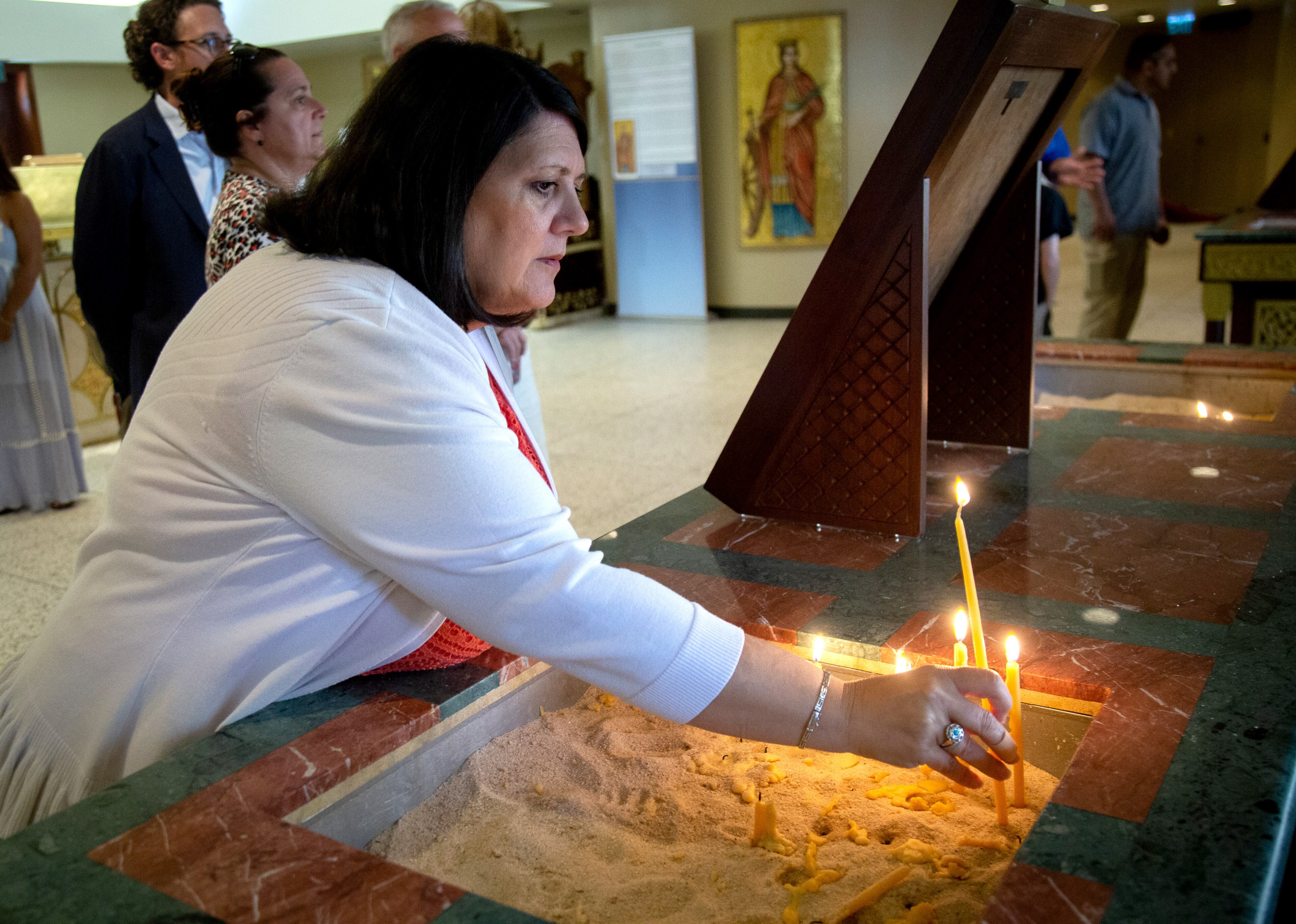Gigi Rax lights a candle and prays as she enters the Cathedral of the Annunciation during the Atlanta Greek Festival on Sunday, September 29, 2019. STEVE SCHAEFER / SPECIAL TO THE AJC