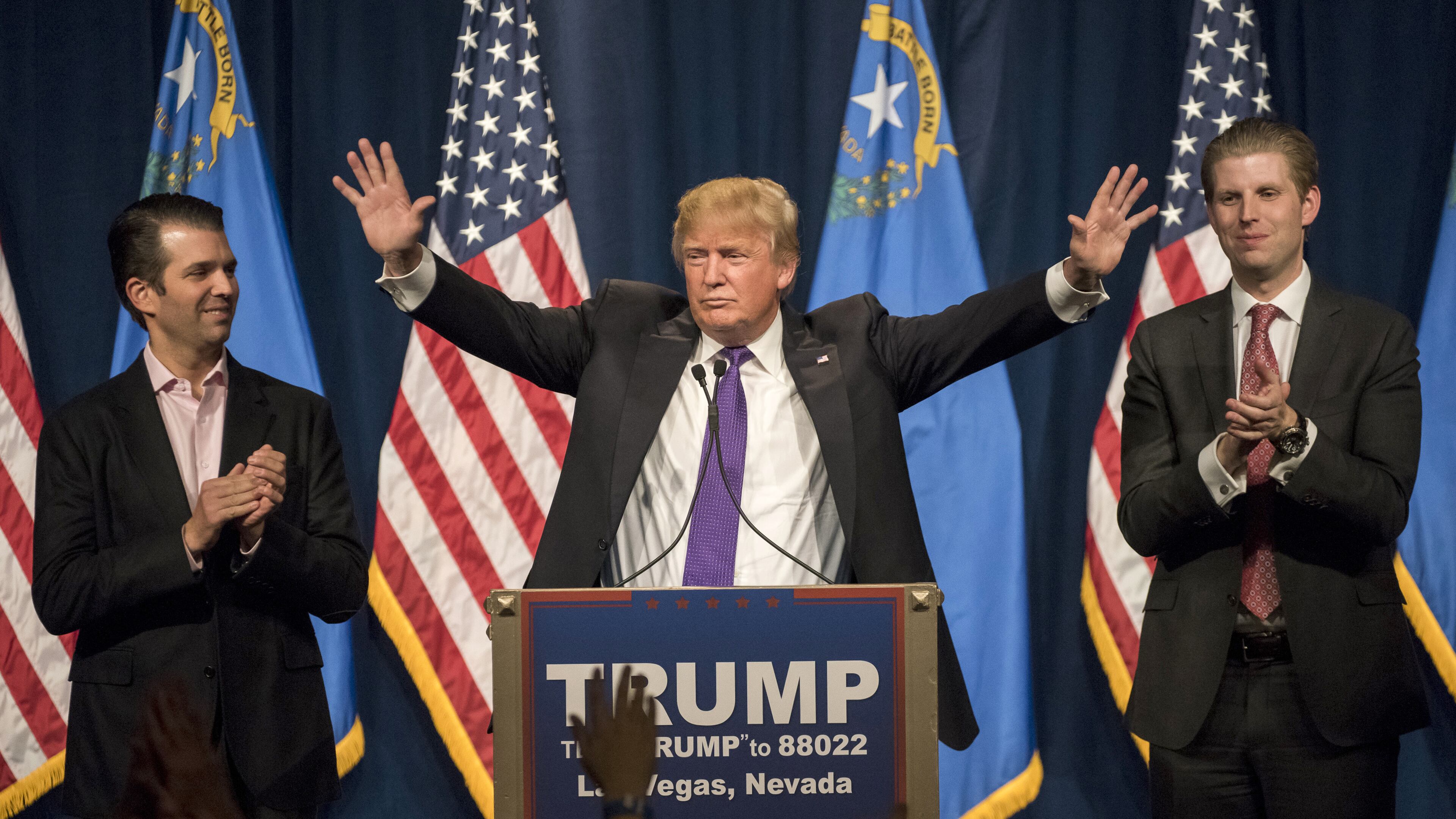 Donald Trump Jr., left, and Eric Trump, right, applaud their father during a caucus night rally in Las Vegas on Feb. 23, 2016.