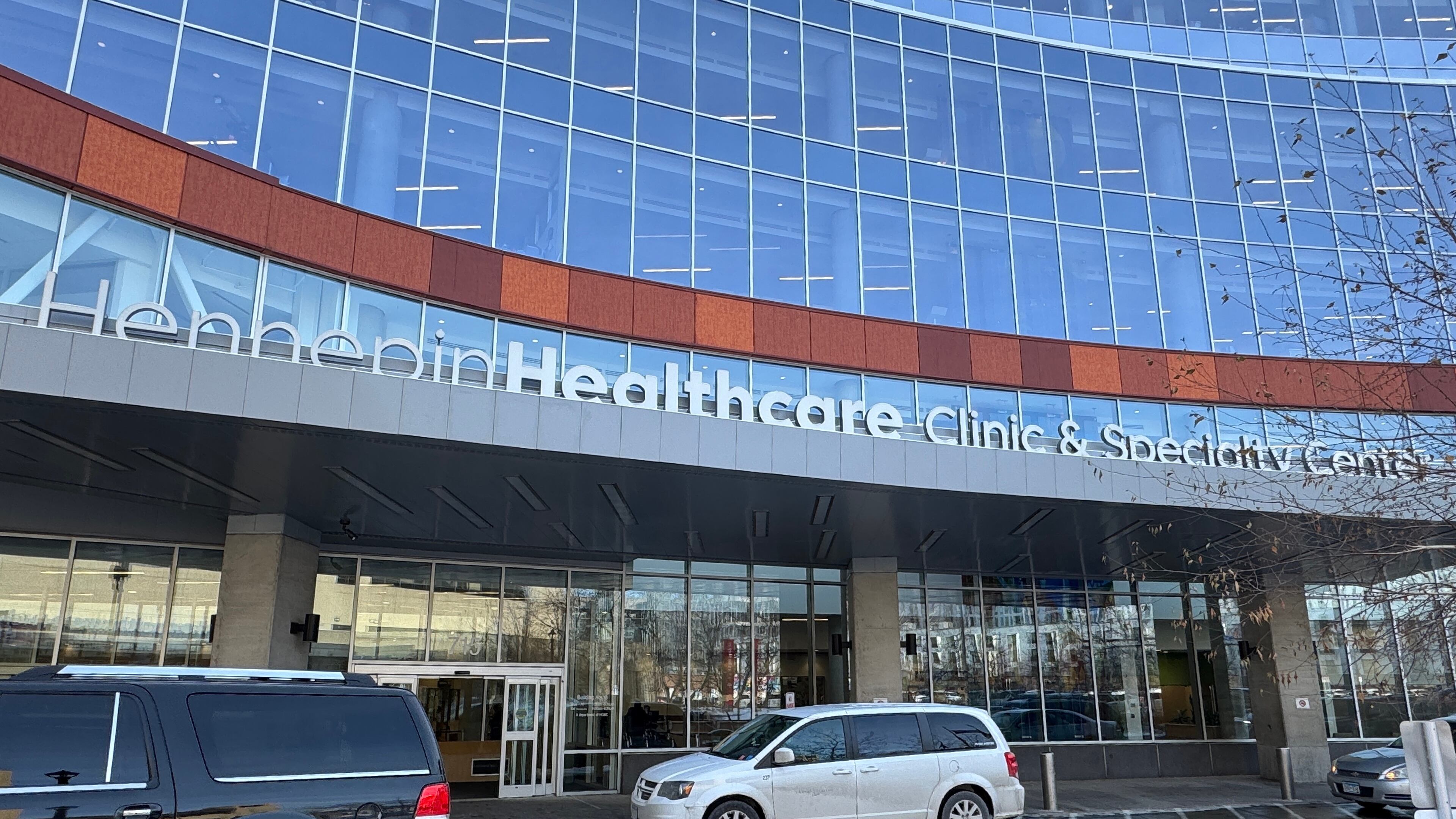 Cars are parked outside Hennepin County Medical Center on Tuesday, Jan. 20, 2026, in Minneapolis. (AP Photo/Sarah Raza)