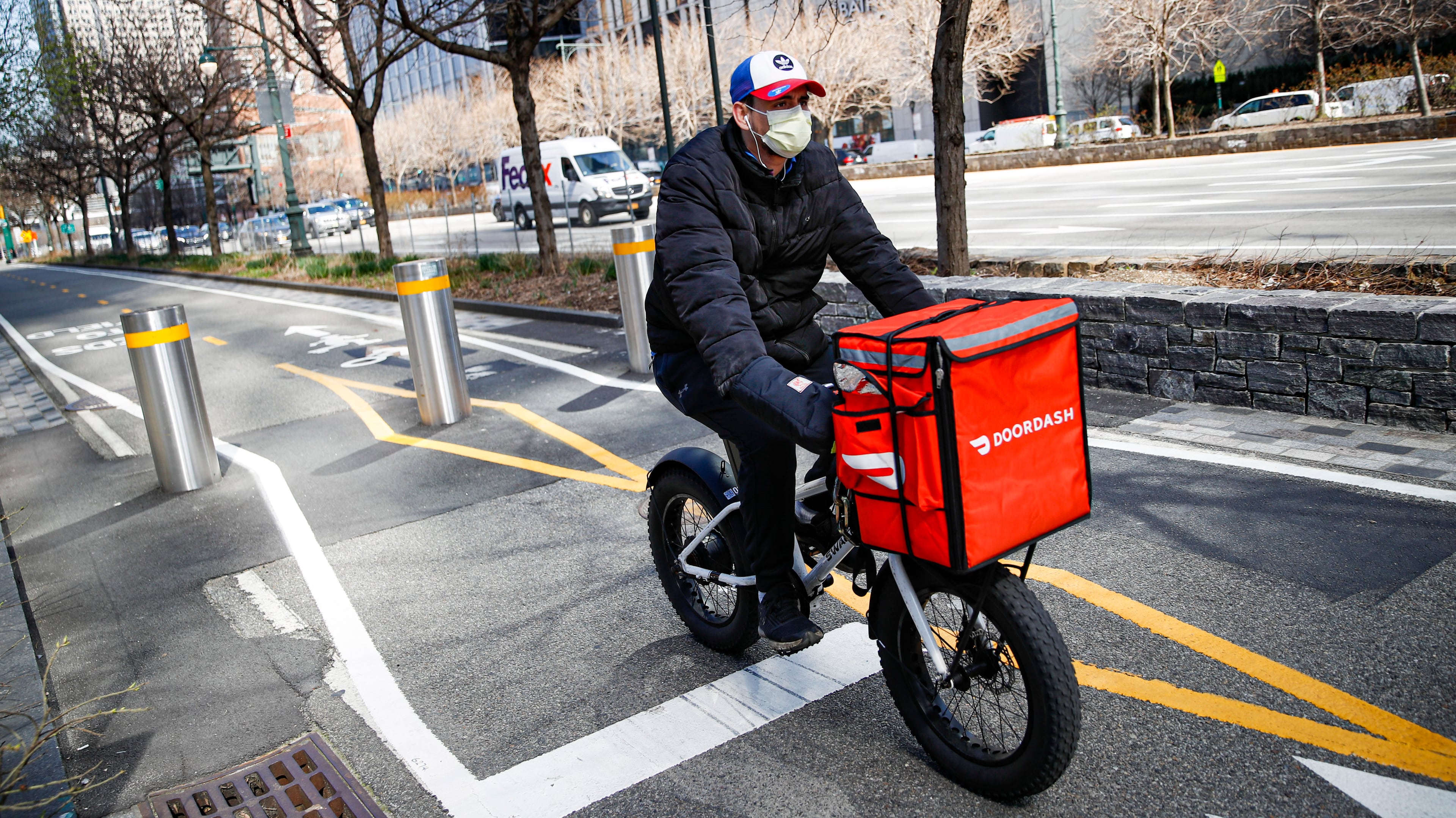 FILE - A delivery worker rides his bicycle along a path on the West Side Highway in New York on March 16, 2020. (AP Photo/John Minchillo, File)