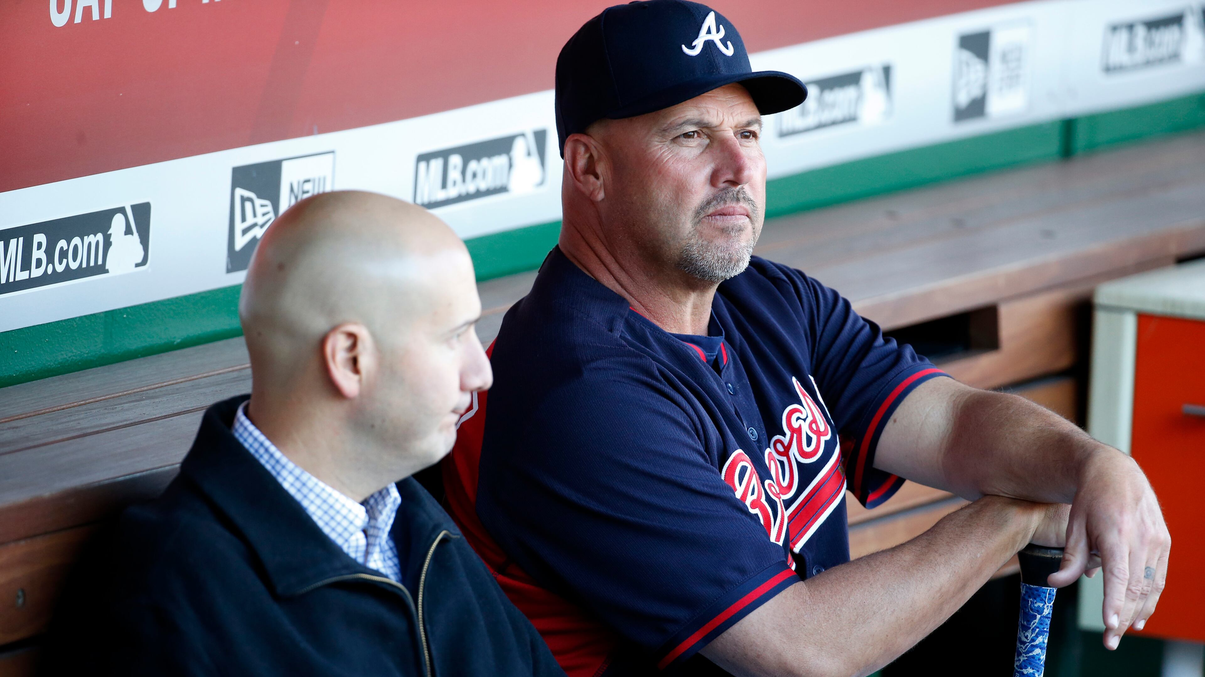 Braves general manager John Coppolella (left) and manager Fredi Gonzalez sit in the dugout at Nationals Park in Washington D.C. before speaking with the media after outfielder Hector Olivera was arrested when a woman accused him of assault and battery. (AP photo)