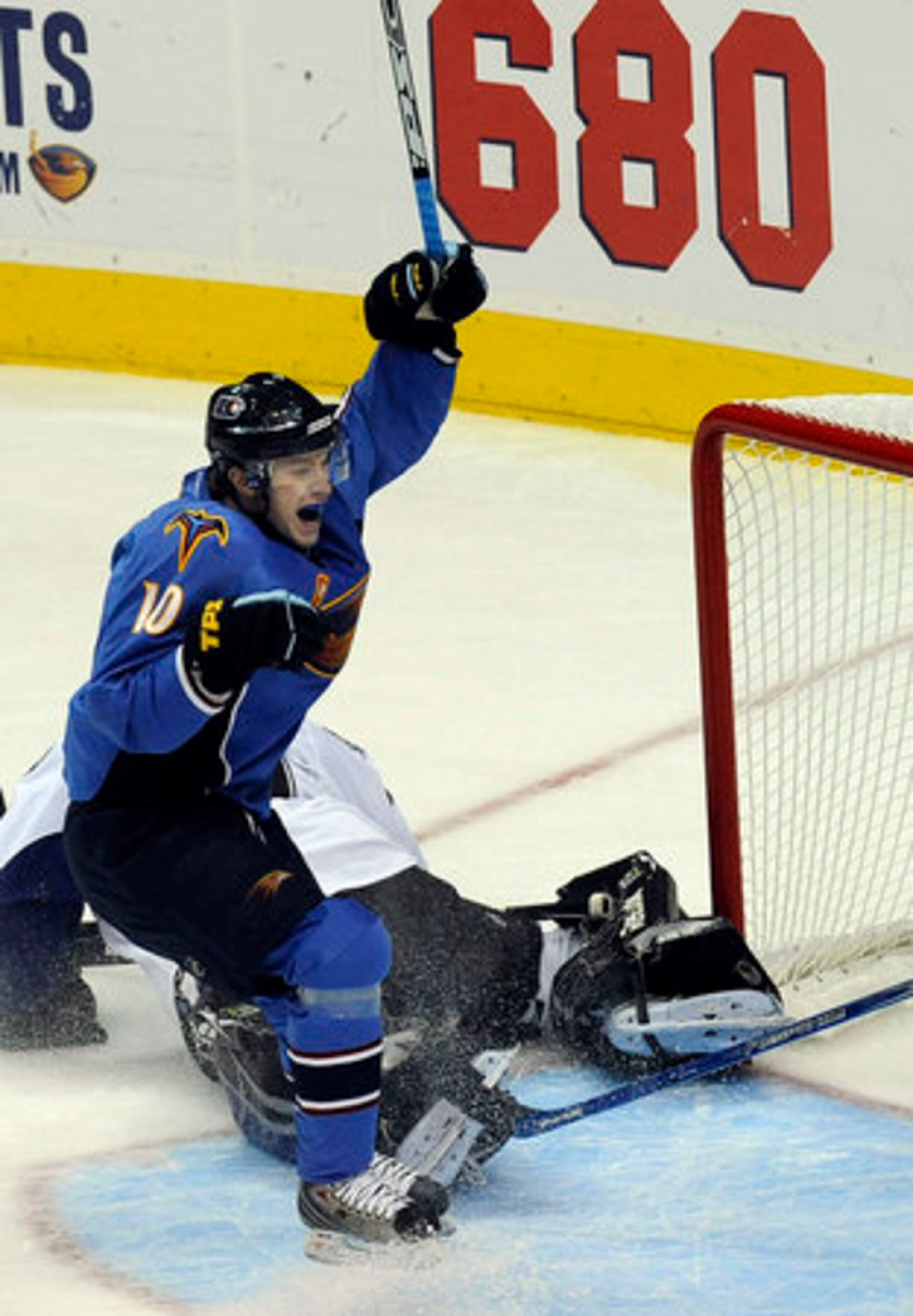 Thrashers forward Bryan Little beats Lightning goalie Mike Smith for the team's first score of the season.