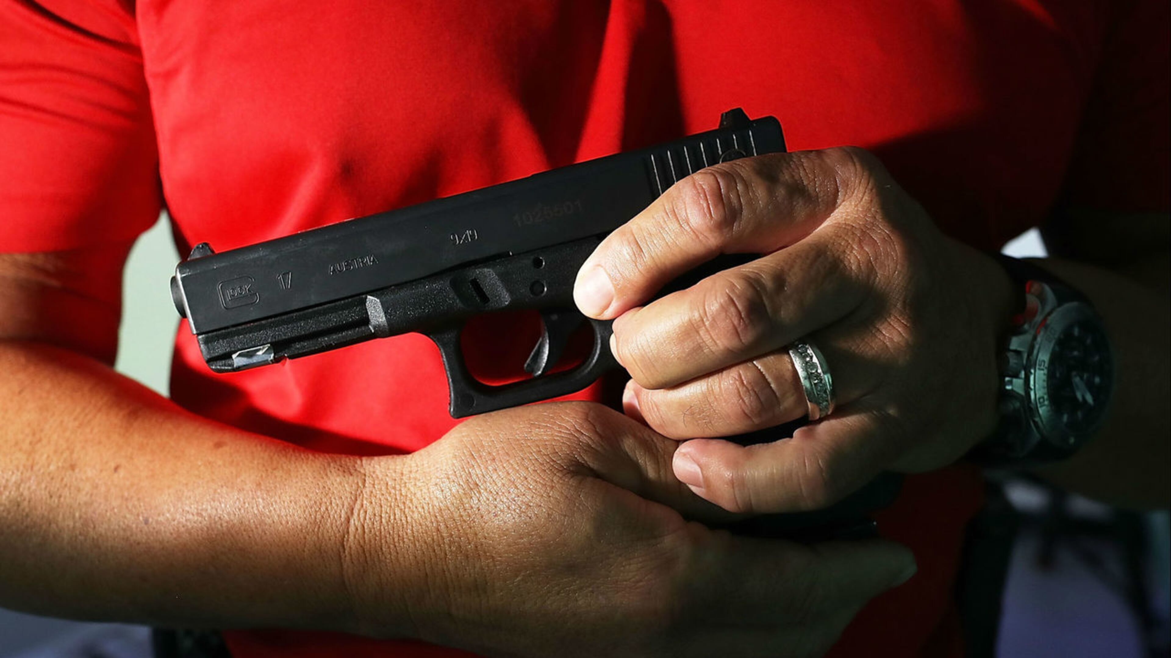 Miami police training officer Luis Gonzalez holds his pistol as he takes part in a demonstration Aug. 7, 2018.
