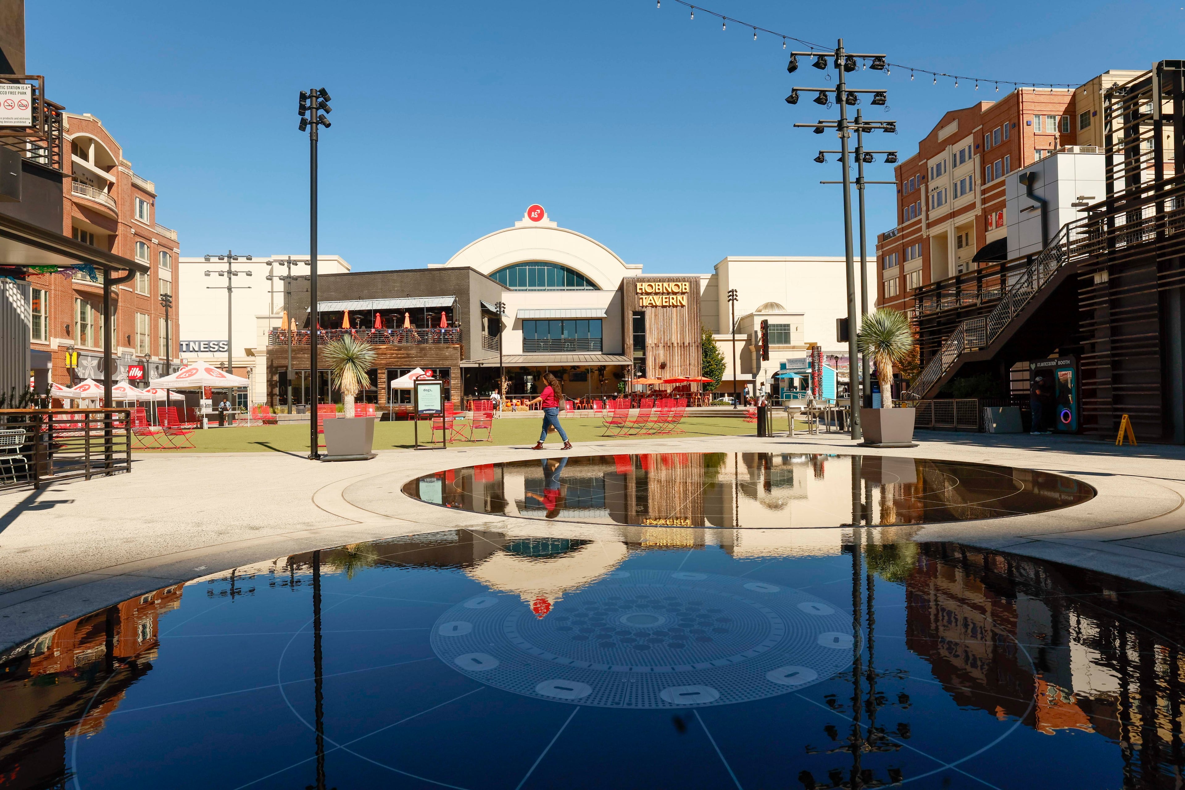A person walks in the main square with the Regal Cinemas in the background at Atlantic Station on Thursday, Oct. 16, 2025. (Miguel Martinez/AJC)