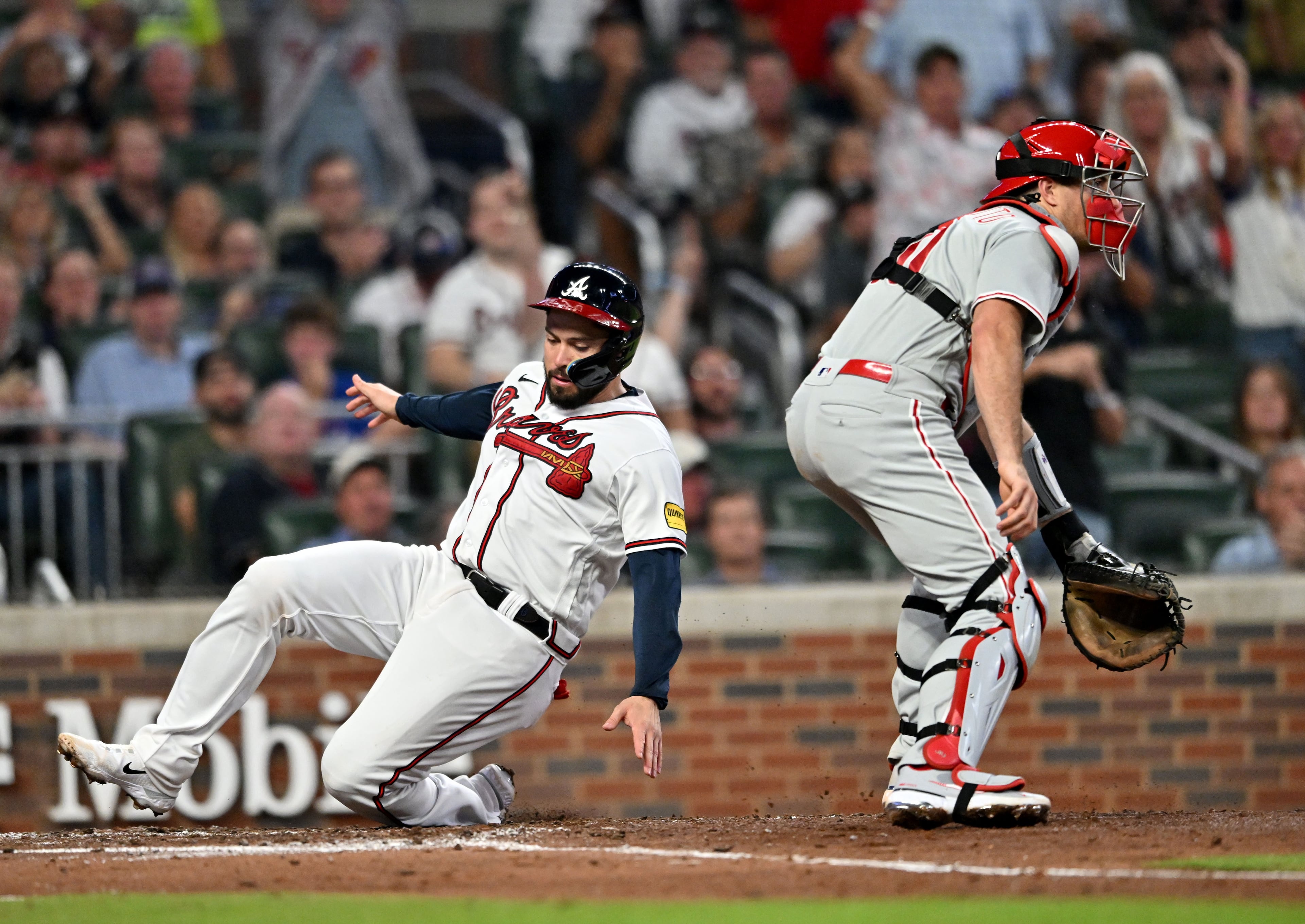 Atlanta Braves' catcher Travis d'Arnaud (16) scores past Philadelphia Phillies' catcher J.T. Realmuto (10) on a 2-RBI single by left fielder Kevin Pillar during the fourth inning at Truist Park, Tuesday, September 19, 2023, in Atlanta. Atlanta Braves won 9-3 over Philadelphia Phillies. (Hyosub Shin / Hyosub.Shin@ajc.com)