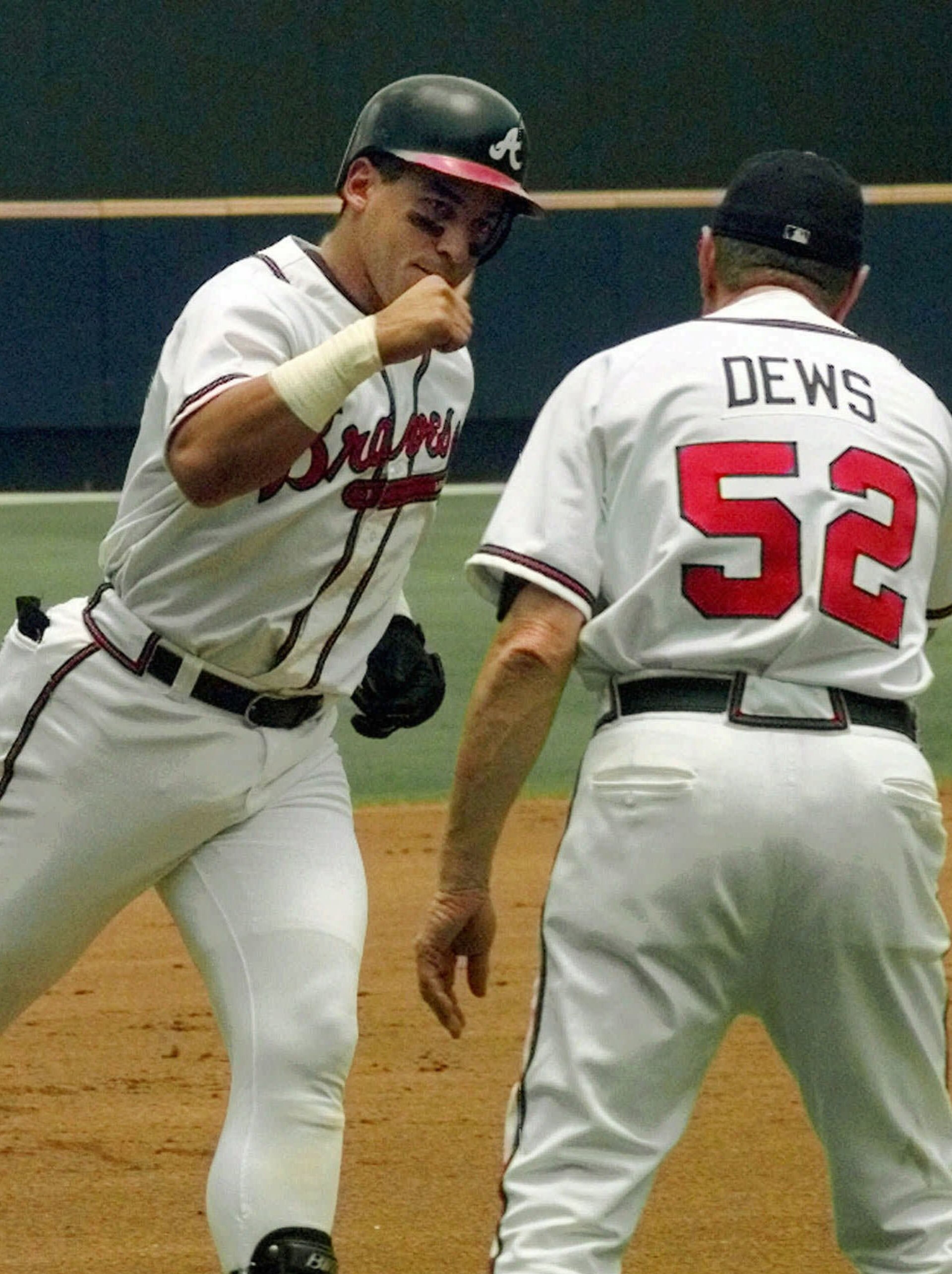 Atlanta Braves' Andres Galarraga, left, is congratulated by third base coach Bobby Dews after his second inning home run off New York Mets pitcher Rick Reed at Turner Field in Atlanta, Sunday, July 5, 1998. (AP Photo/Ric Feld)