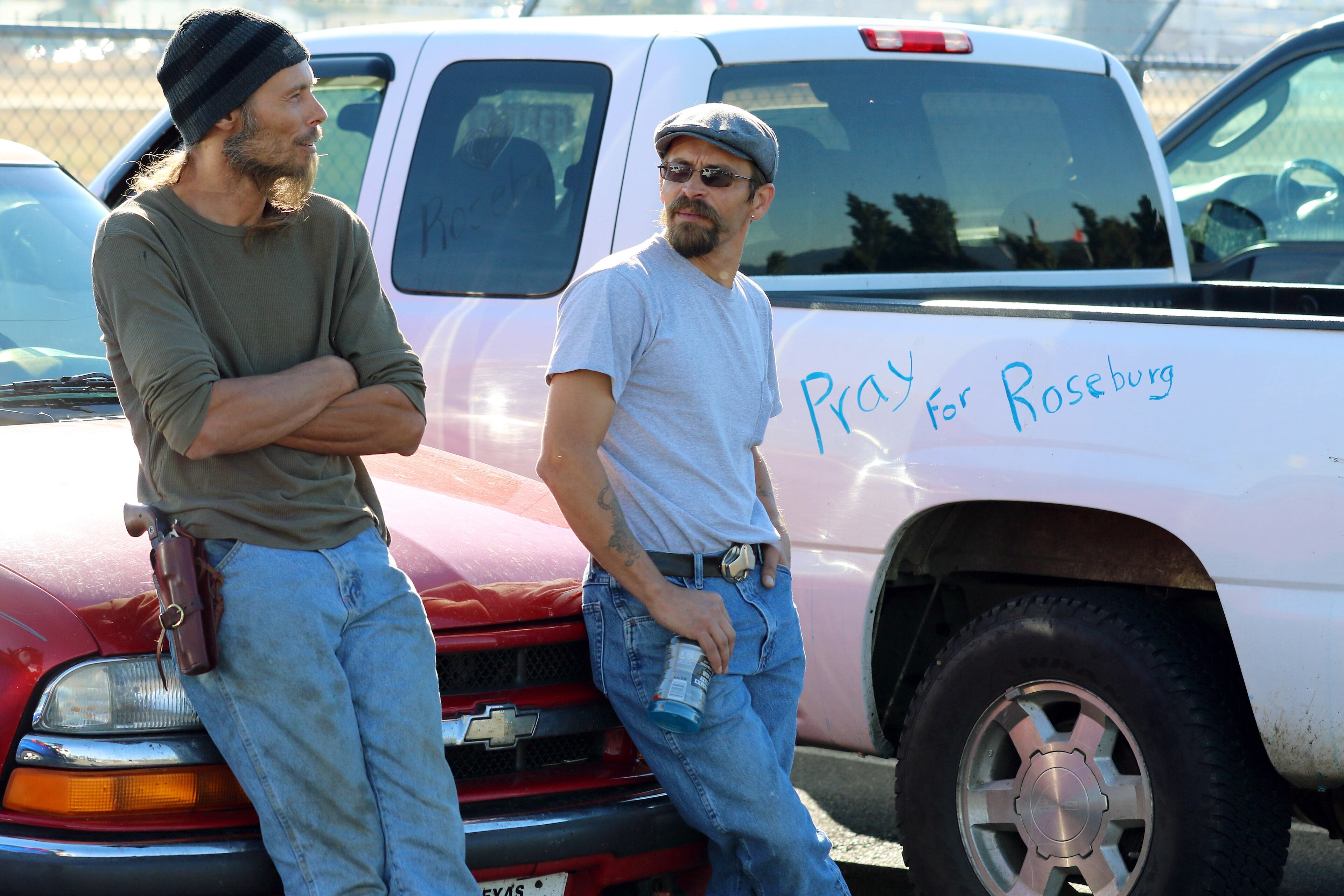 Demonstrators wearing firearms wait outside of Roseburg Regional Airport for President Barack Obama's arrival, Friday, Oct. 9, 2015, in Roseburg, Ore. Angry with Obama for calling for tighter gun restrictions in the wake of last week's deadly shootings at Umpqua Community College, gun-rights activists gathered to protest the president's visit to meet with victims' families. (AP Photo/Ryan Kang)