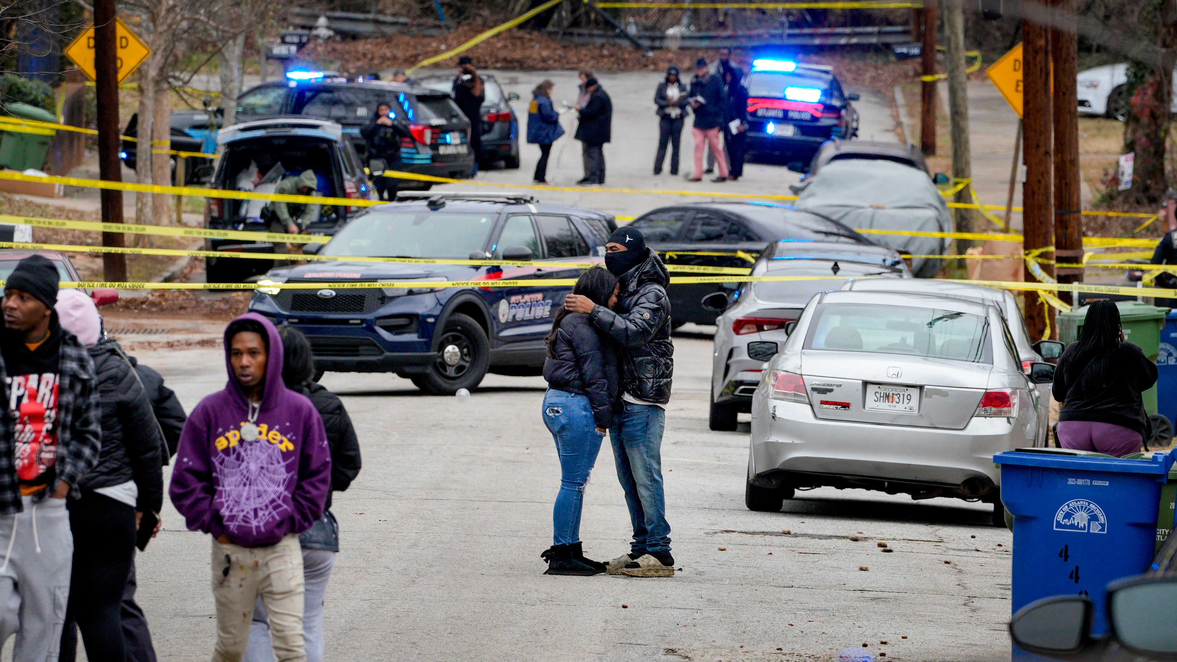 Residents hug on Holderness Street as Atlanta police investigate a fatal shooting Monday.