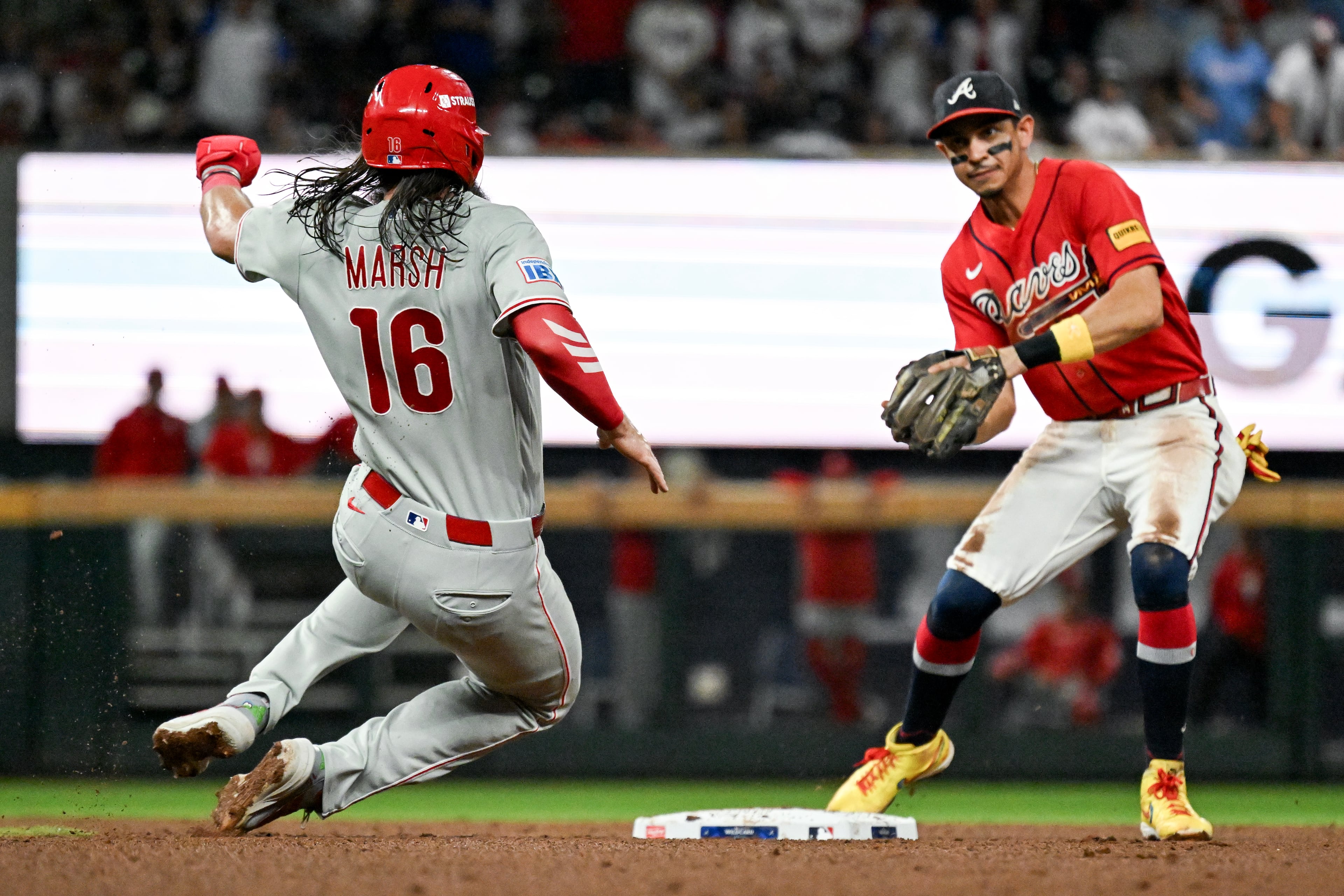 Braves left fielder Mauricio Dubón (right) turns an inning-ending double play against Phillies left fielder Brandon Marsh during Game 3 of their NL Wild Card Series on Thursday, Oct. 1, 2026, at Truist Park in Atlanta. (Hyosub Shin/AJC)