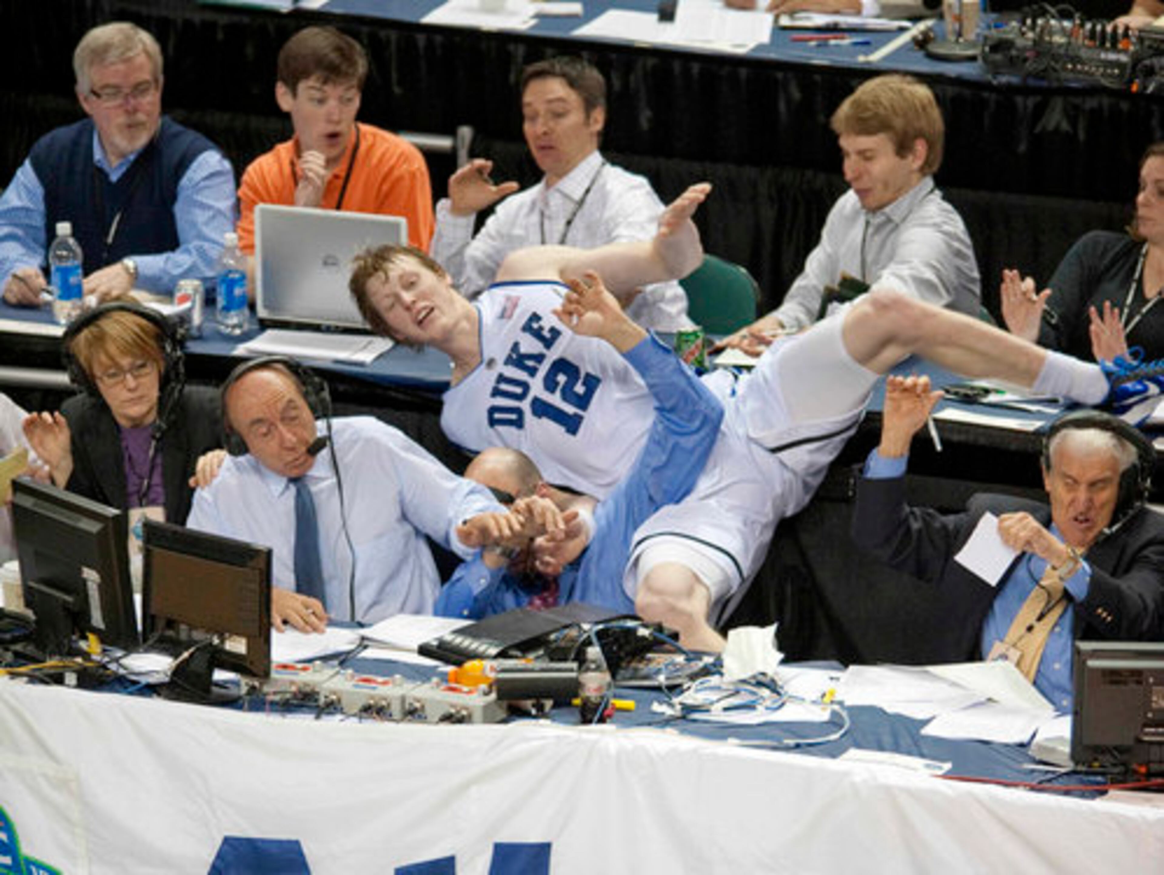 Duke's Kyle Singler (12) collides with ESPN broadcasters Dick Vitale (left) and Dan Shulman as Singler dove into press area after a loose ball.