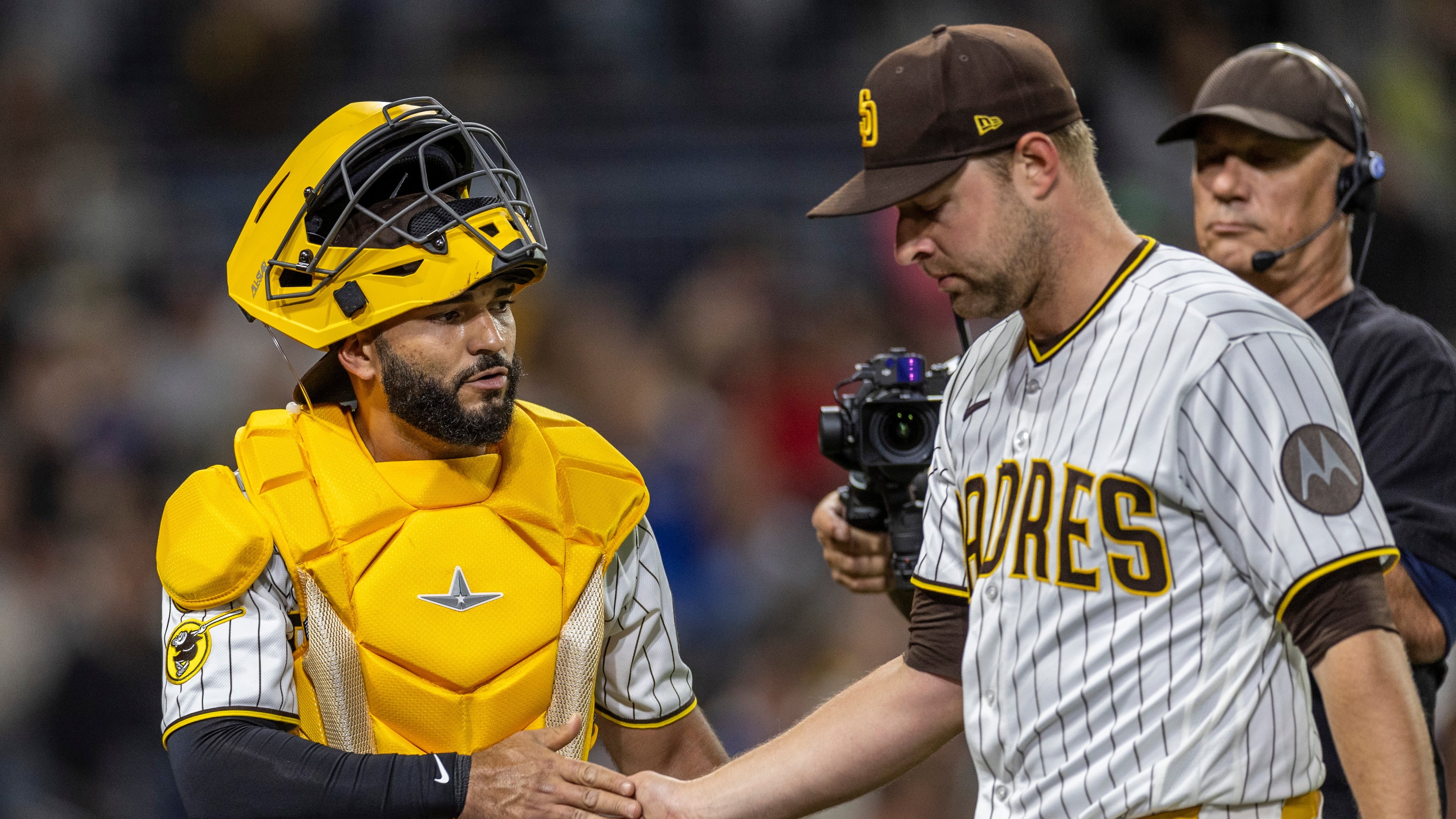 San Diego Padres catcher Rodolfo Durán, left, gives a hand to starting pitcher Michael King, front right, after the in the sixth inning of a baseball game against the Los Angeles Dodgers, Monday, May 18, 2026, in San Diego. (AP Photo/Tony Ding)