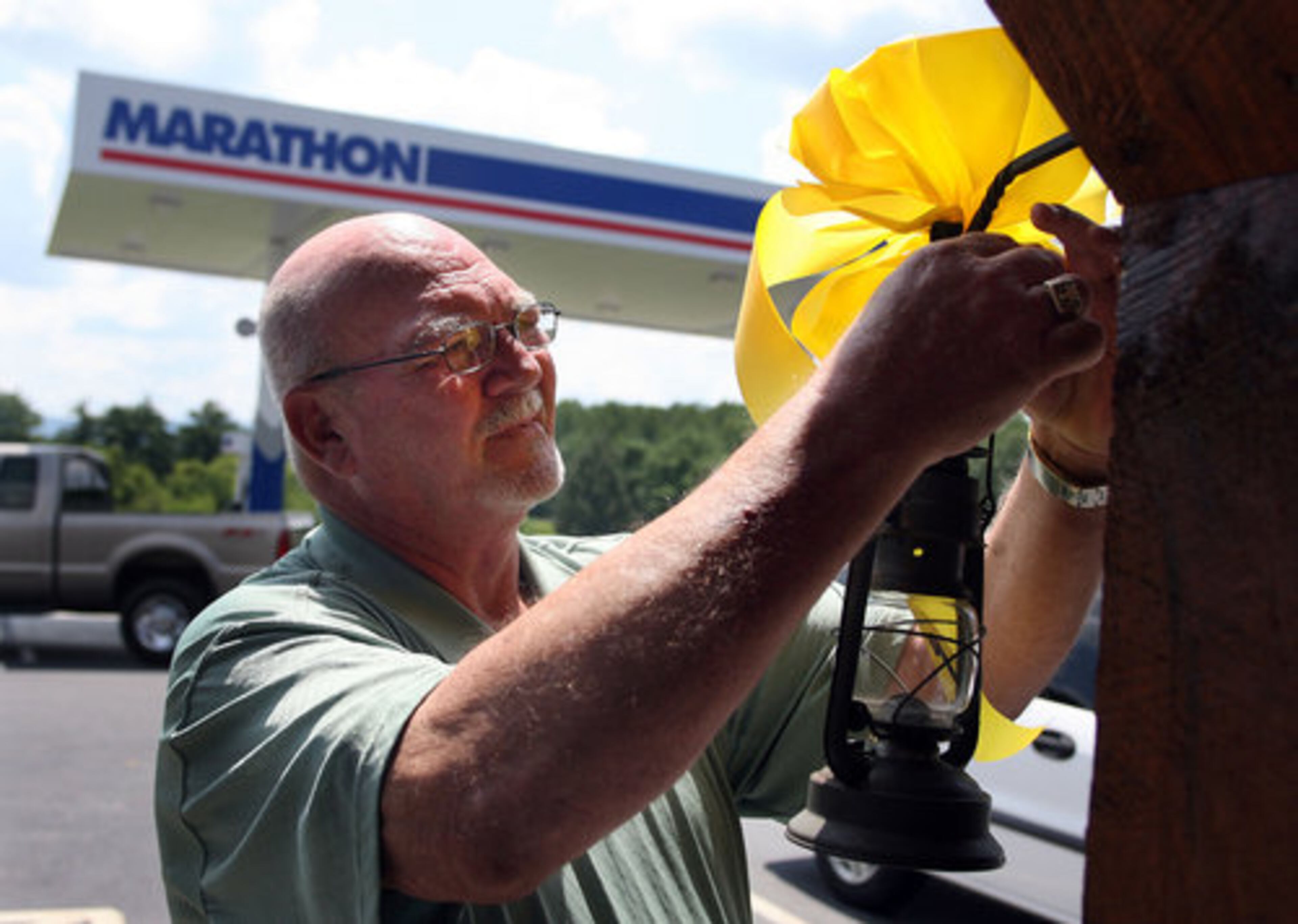 Charles Brackett puts up yellow ribbons at his Blairsville Marathon station in support of the search